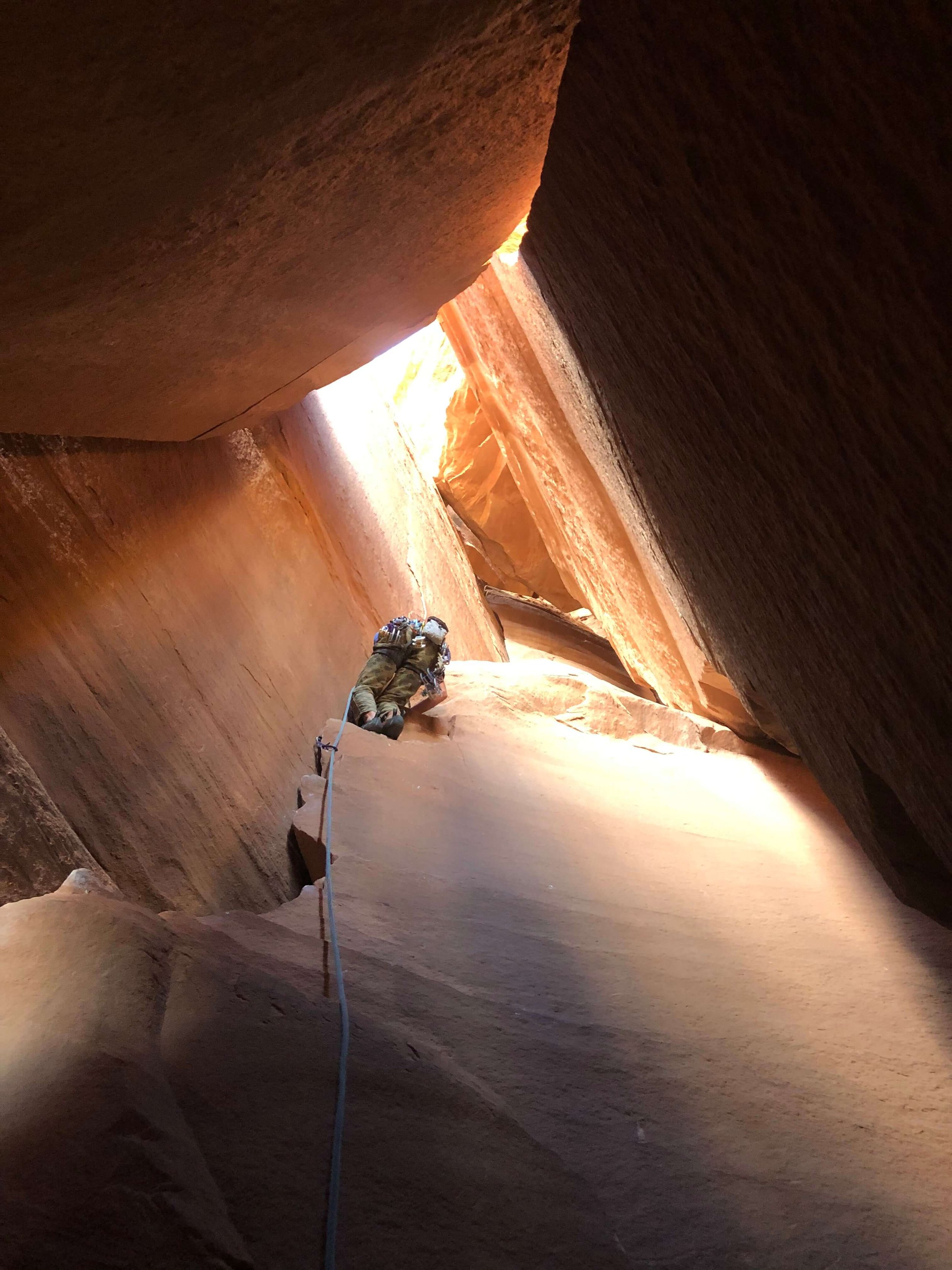 Climbing inside a cave at the Interiors Wall in Escalante Canyon.