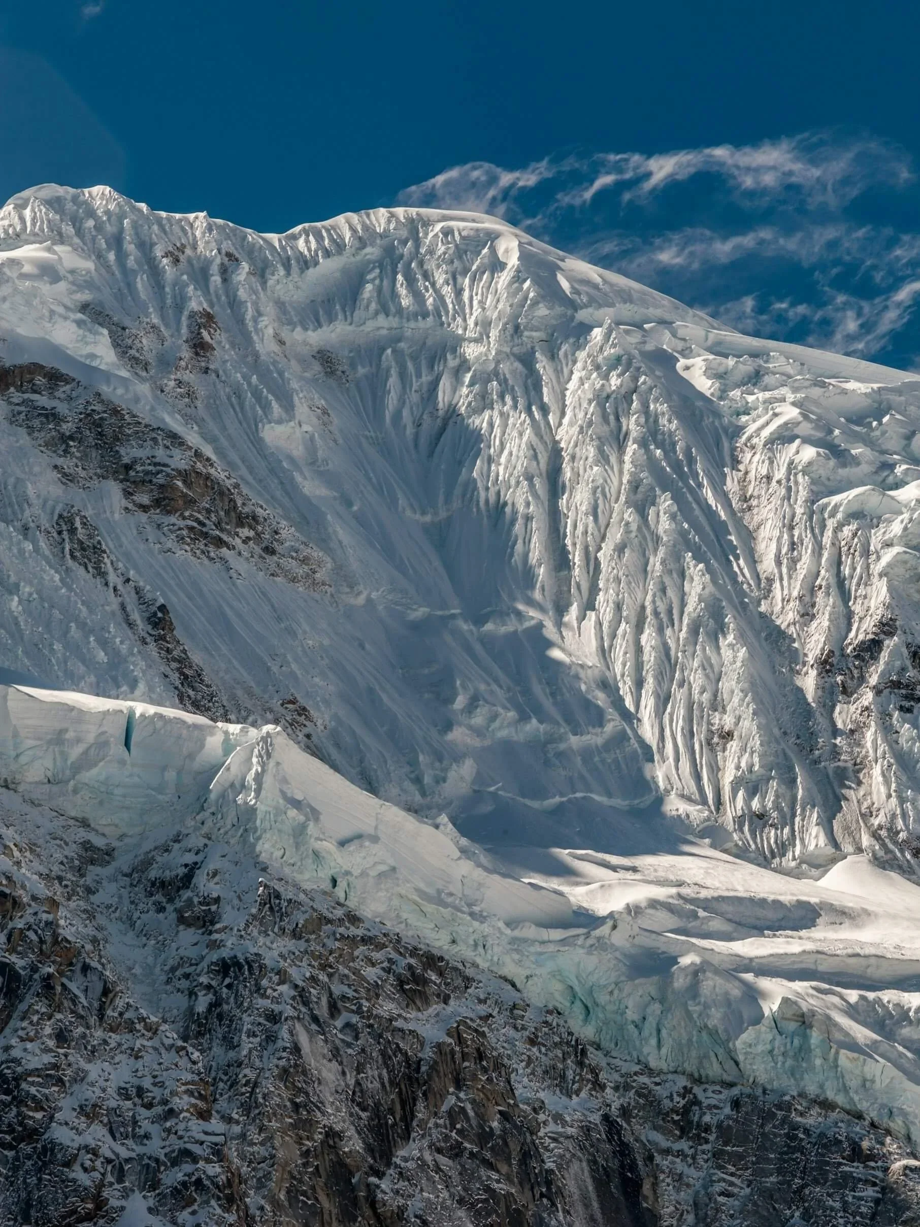 A steep snow face on a glaciated peak in the Peruvian Andes.