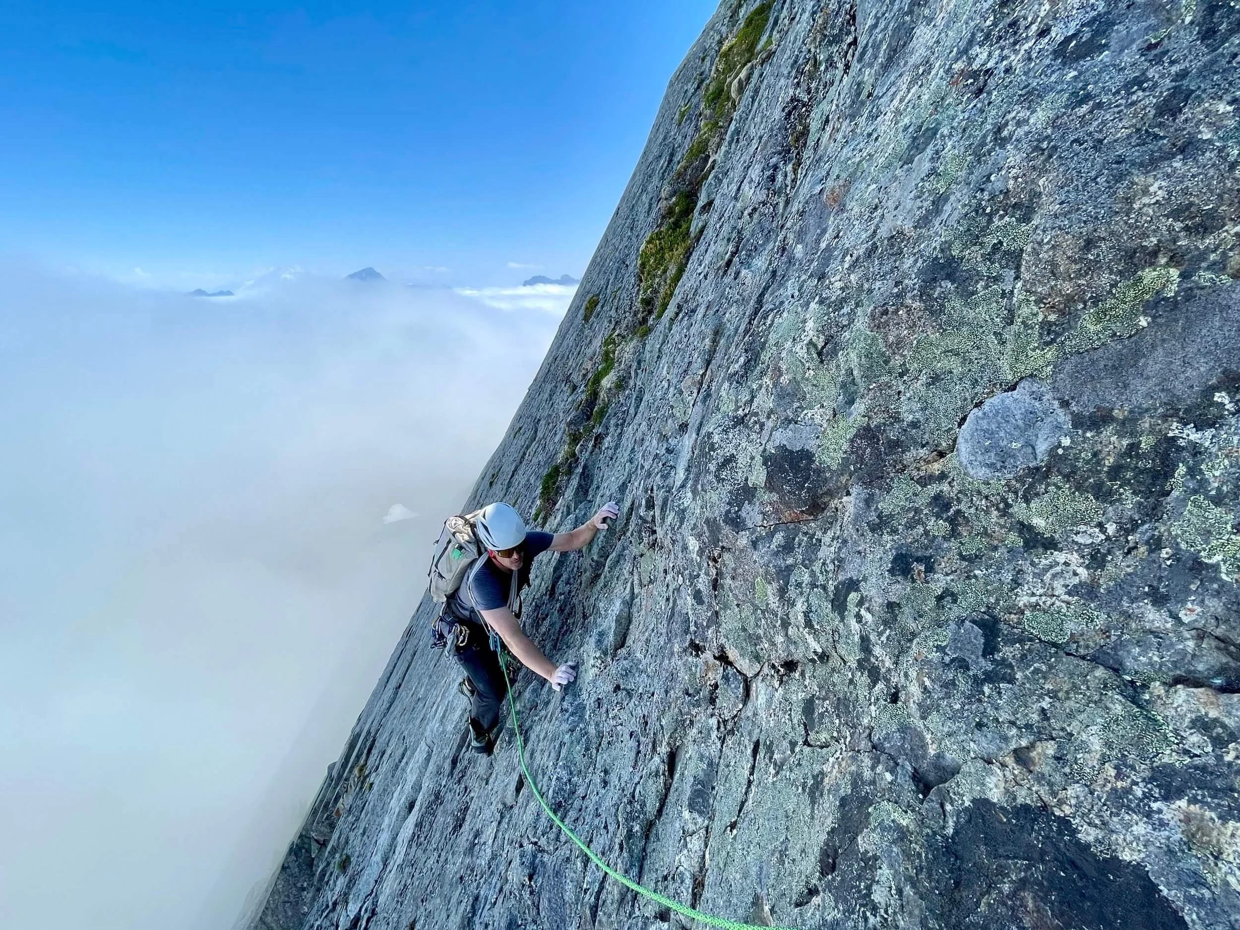 A climber ascends Vesper Peak in the North Cascades above a sea of clouds.