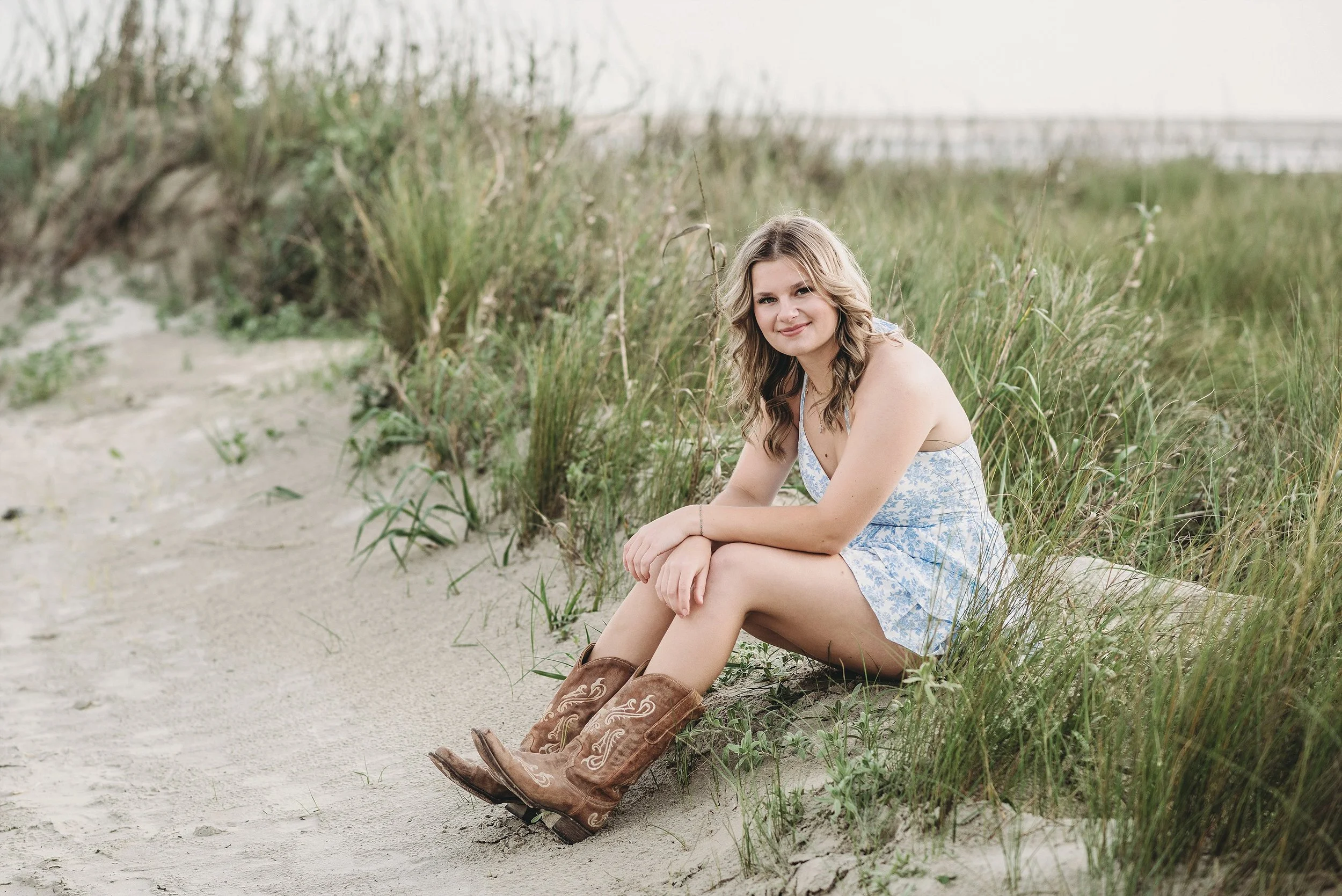 A pearland high school senior girl sitting on a sand dune on the neach