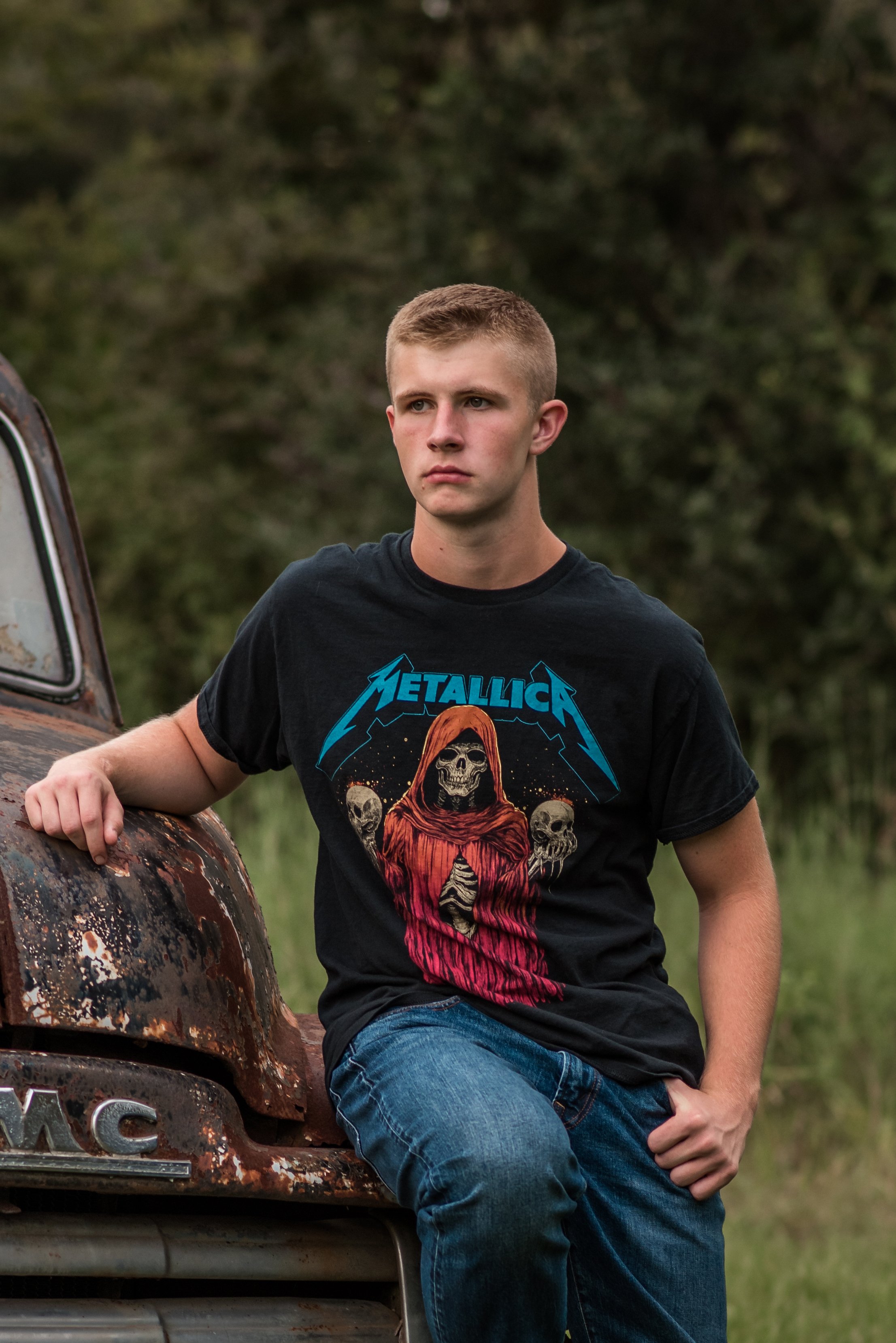 A high school senior boy in a country setting with a truck