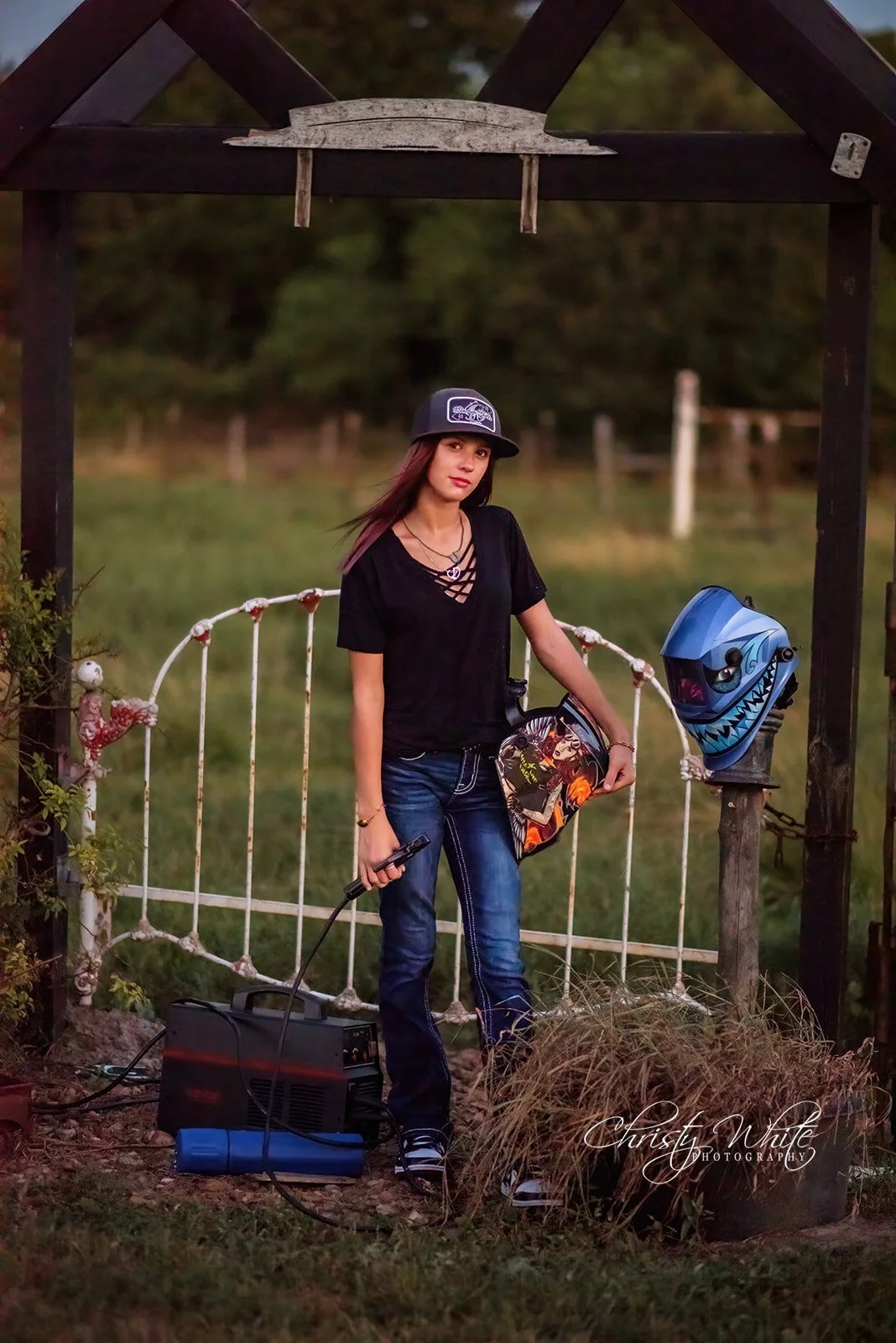Angleton High School senior with welding gear photographed outdoors in warm sunset light
