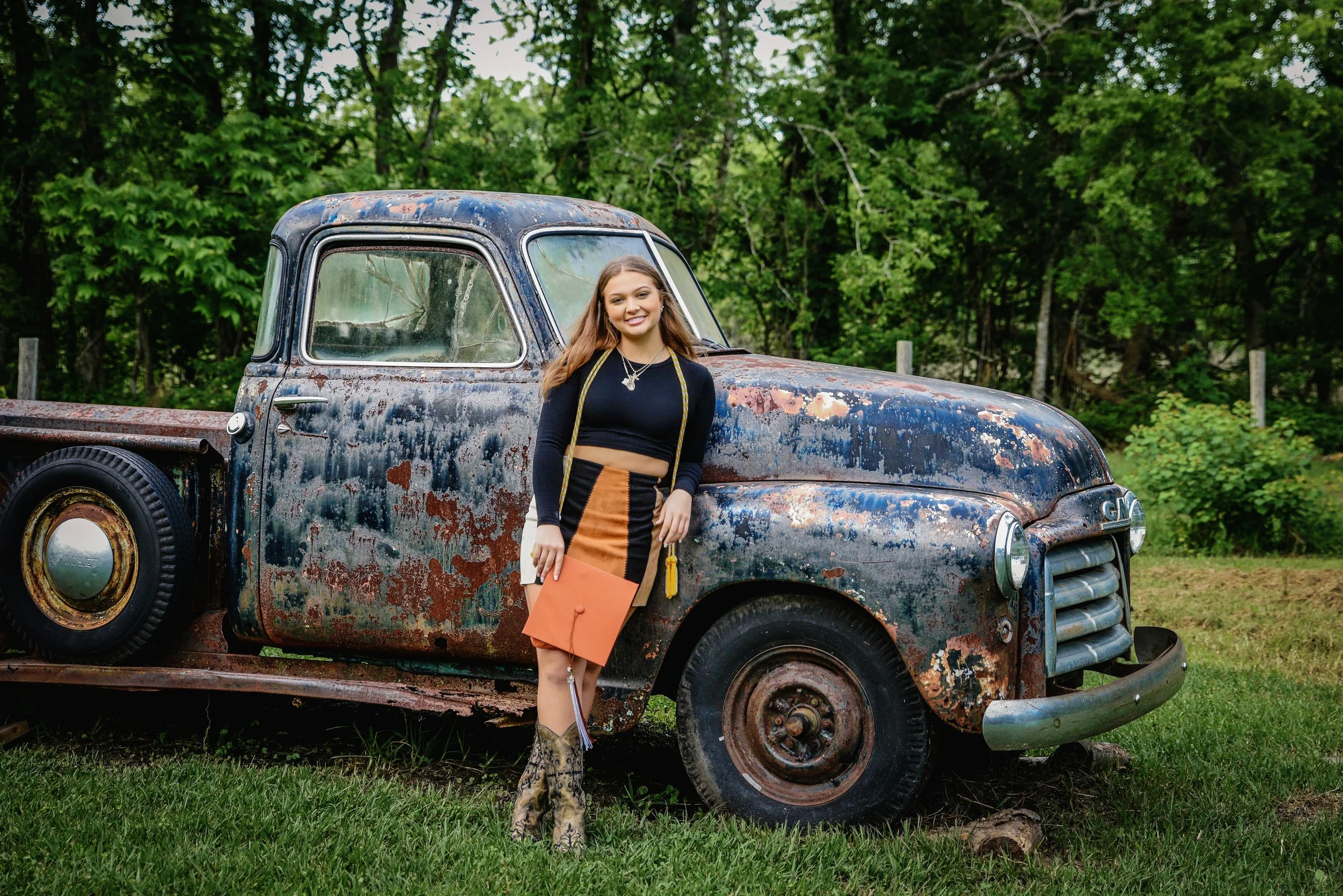 High school senior standing next to a rustic truck