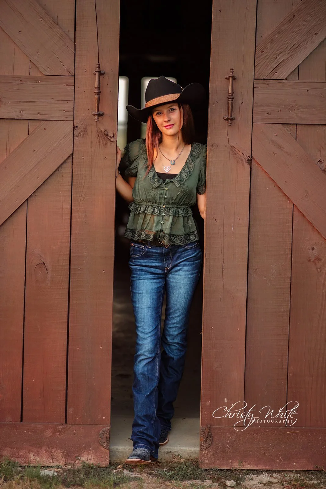 Kendal leaning against weathered wood during her country senior photography session