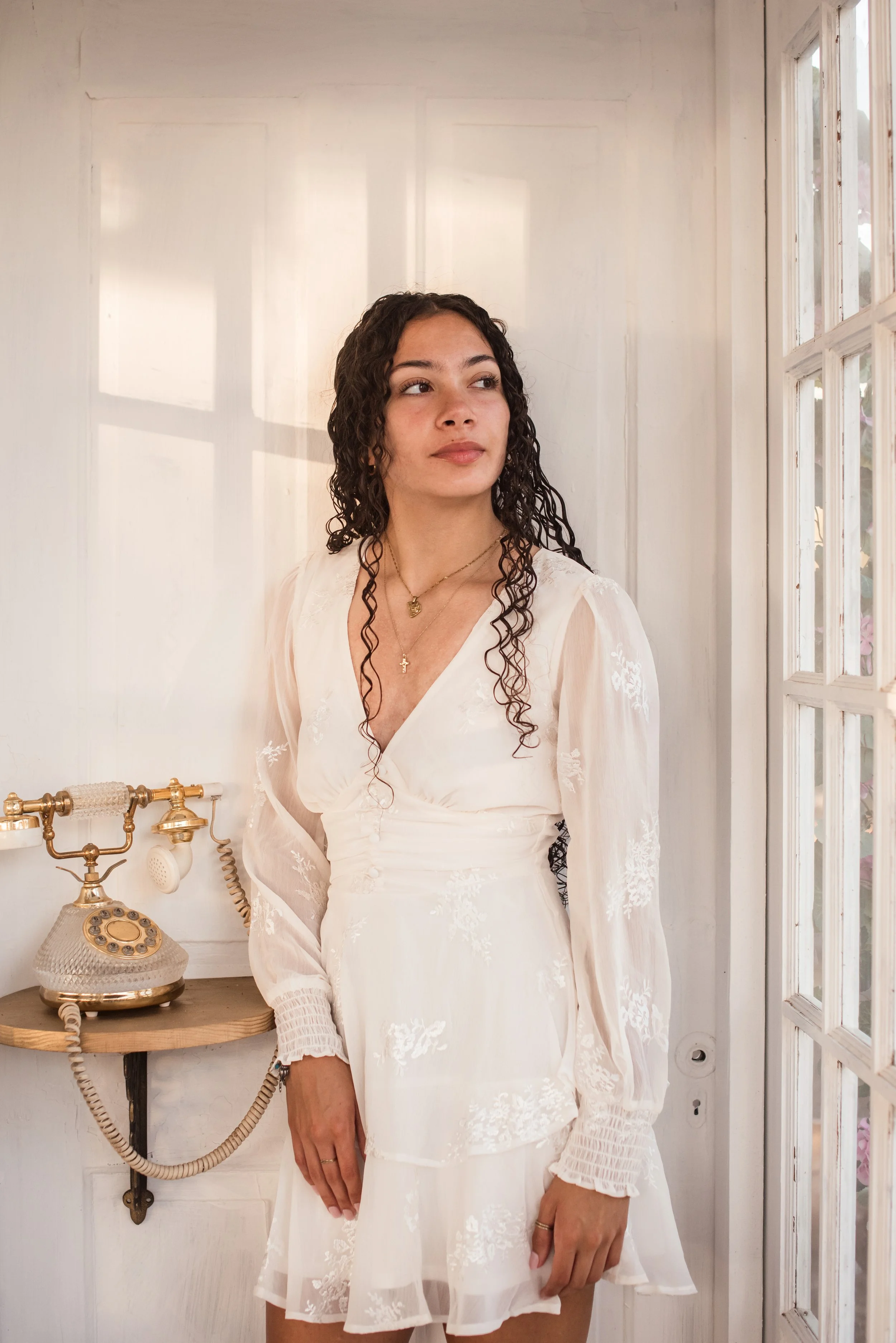 A high school senior girl in a white phone booth