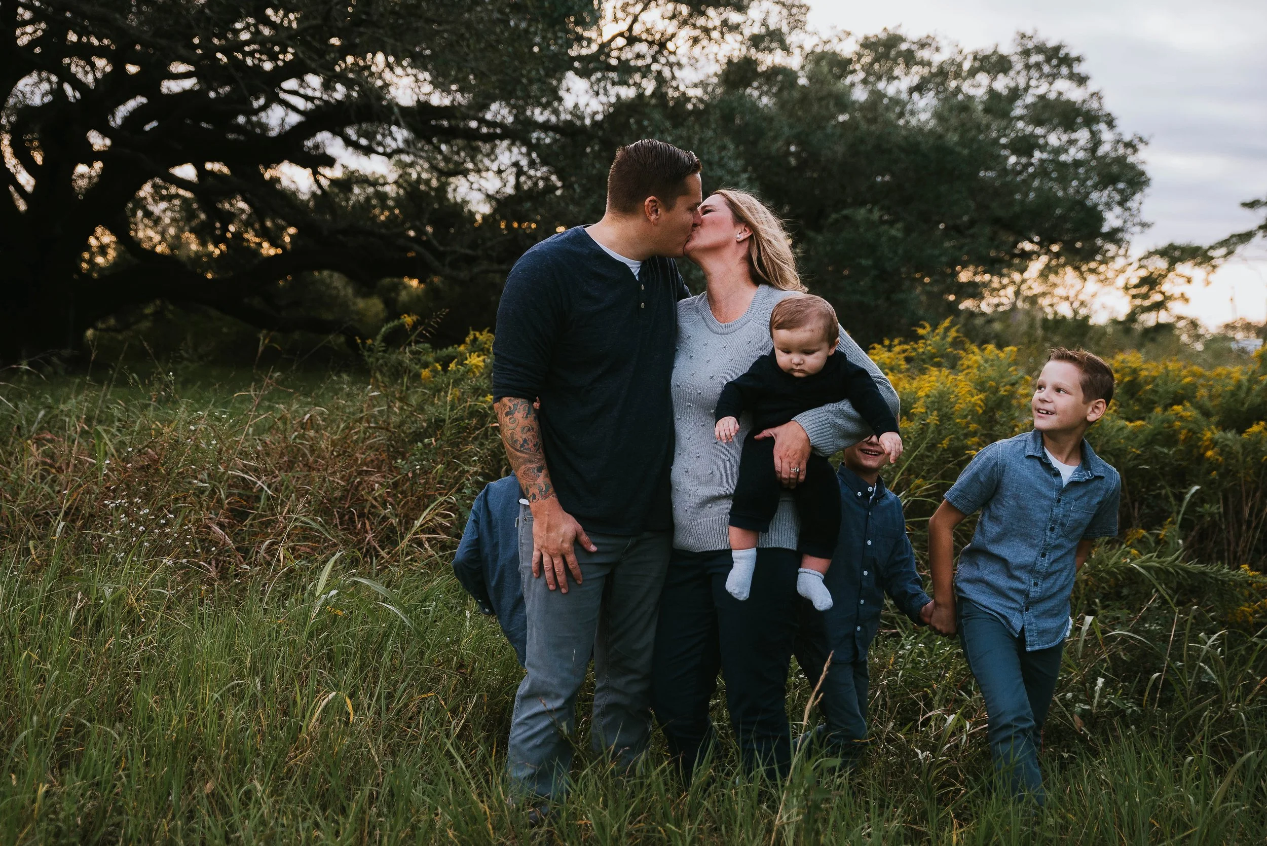 parents with children playing in a field during a family photography session in Alvin Texas