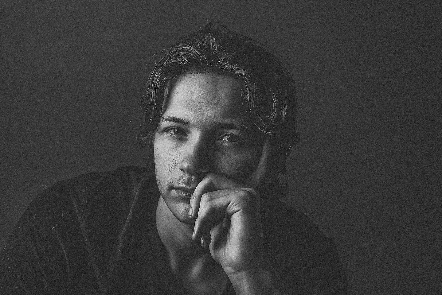 moody studio portrait of a thoughtful young man