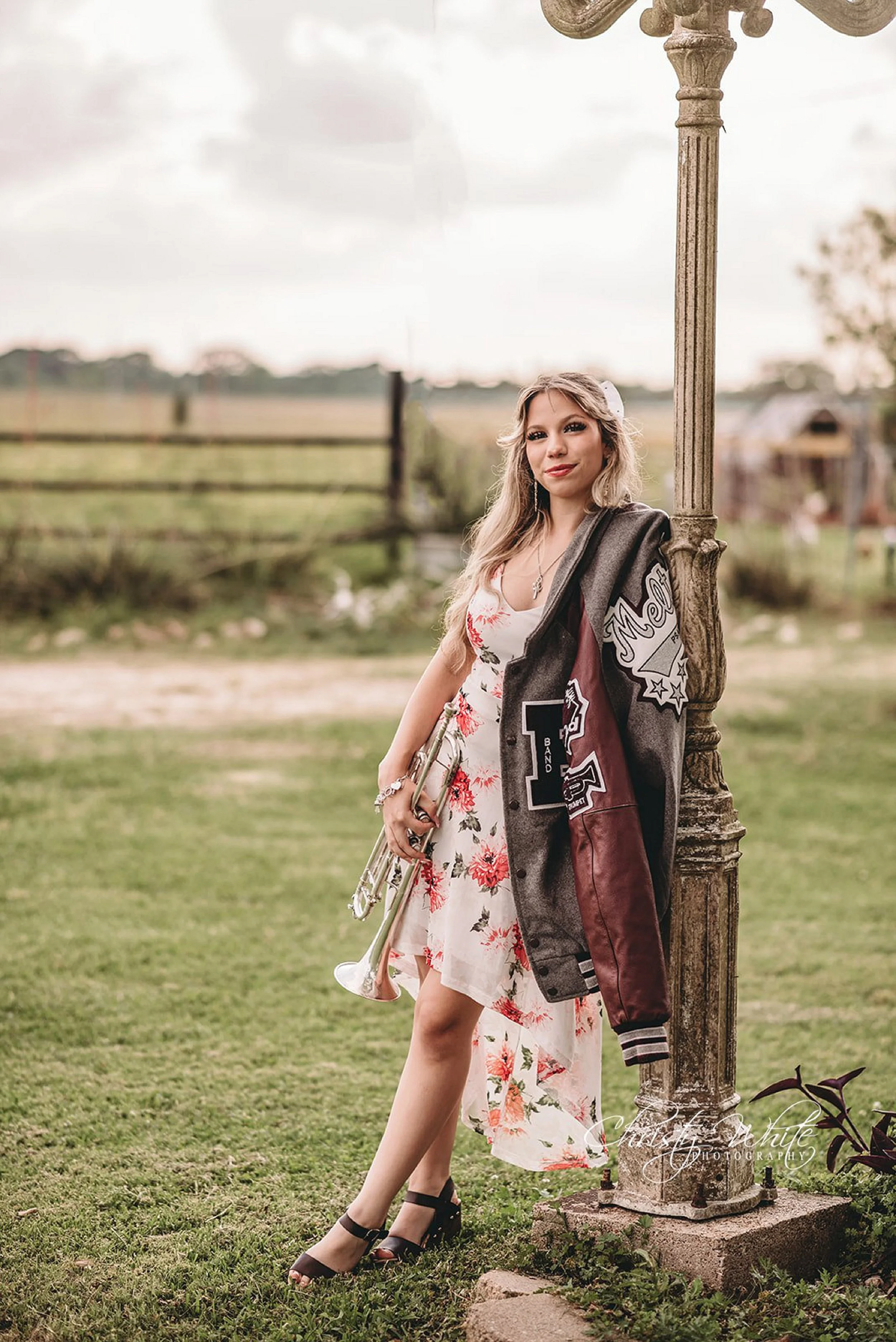 Pearland Texas senior photographer capturing high school senior portraits with her band instrument at a rustic cattle farm near Santa Fe, TX.