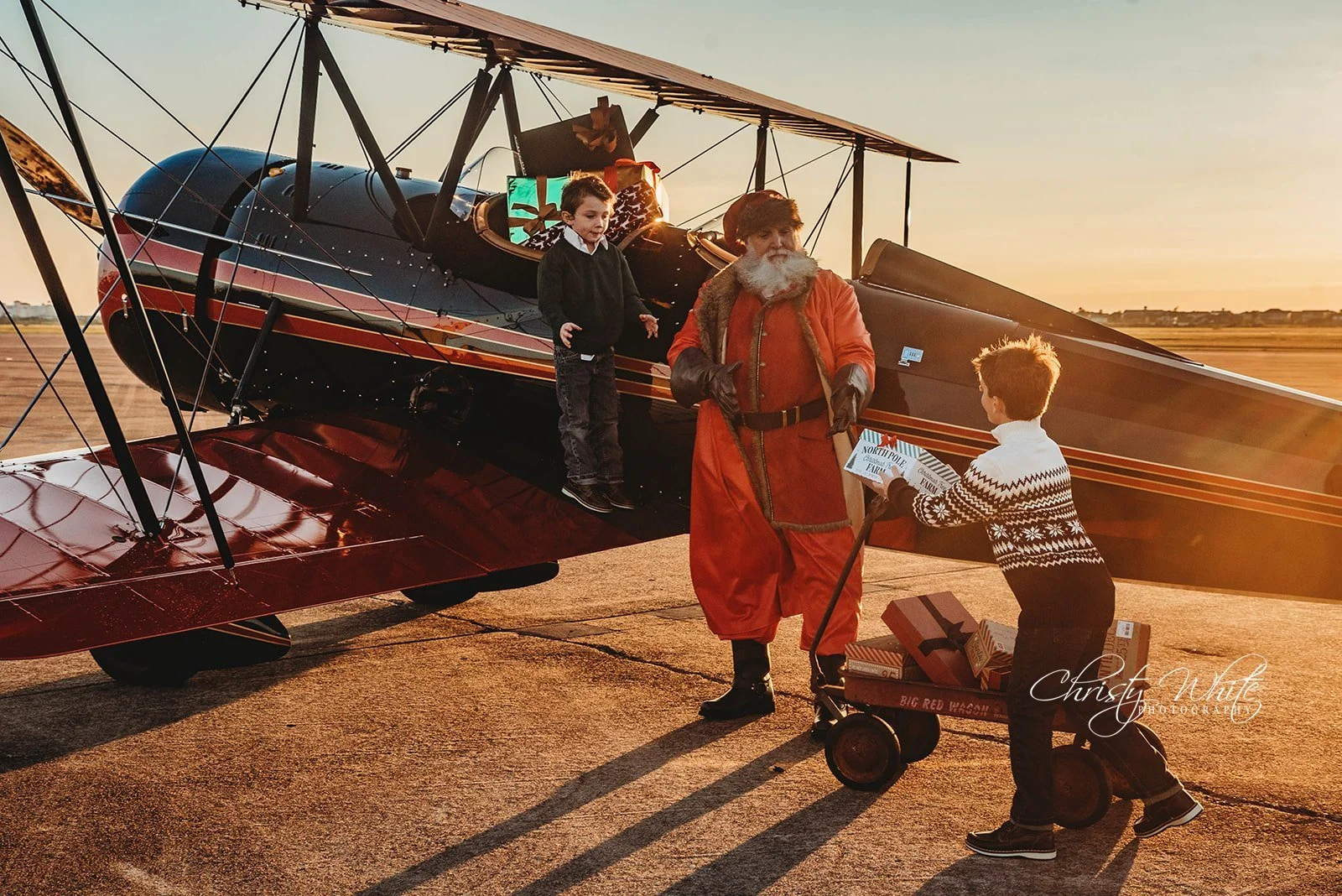 Santa sharing Christmas Magic with a young child in front of airplane.
