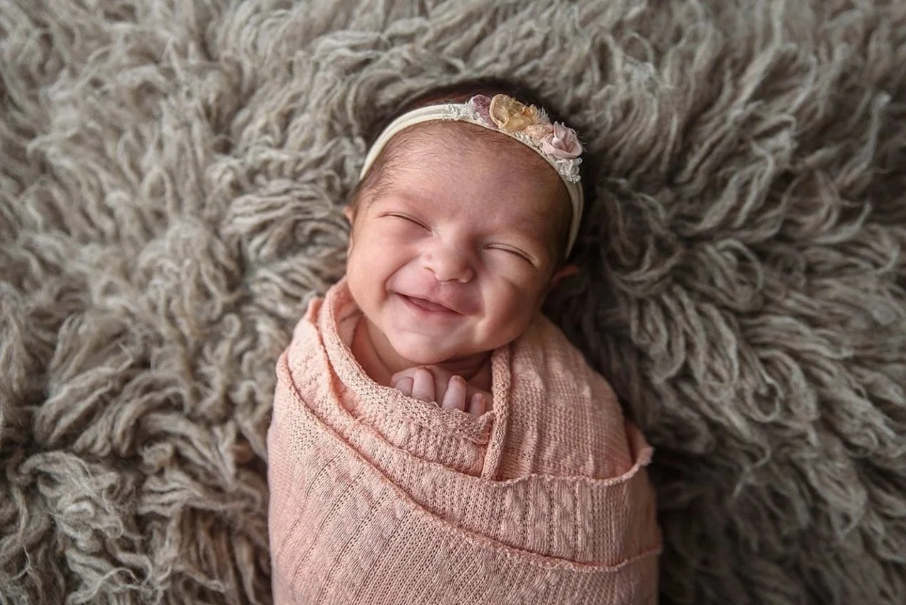 smiling wrapped newborn photography session in Alvin Texas studio