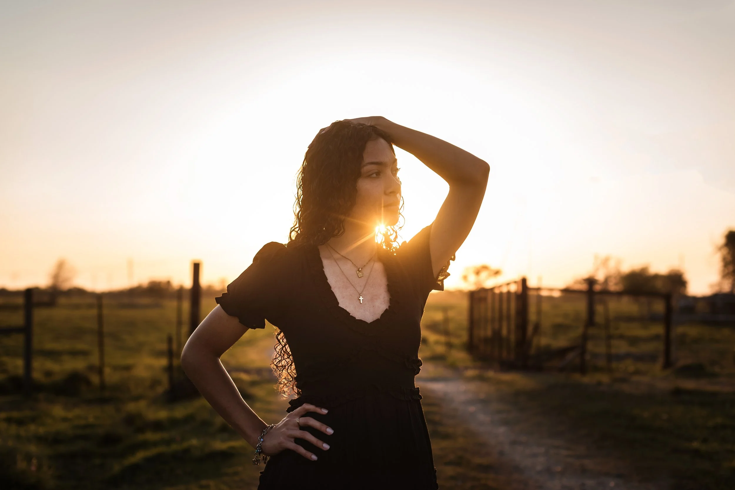 A senior girl at a rustic country session at sunset
