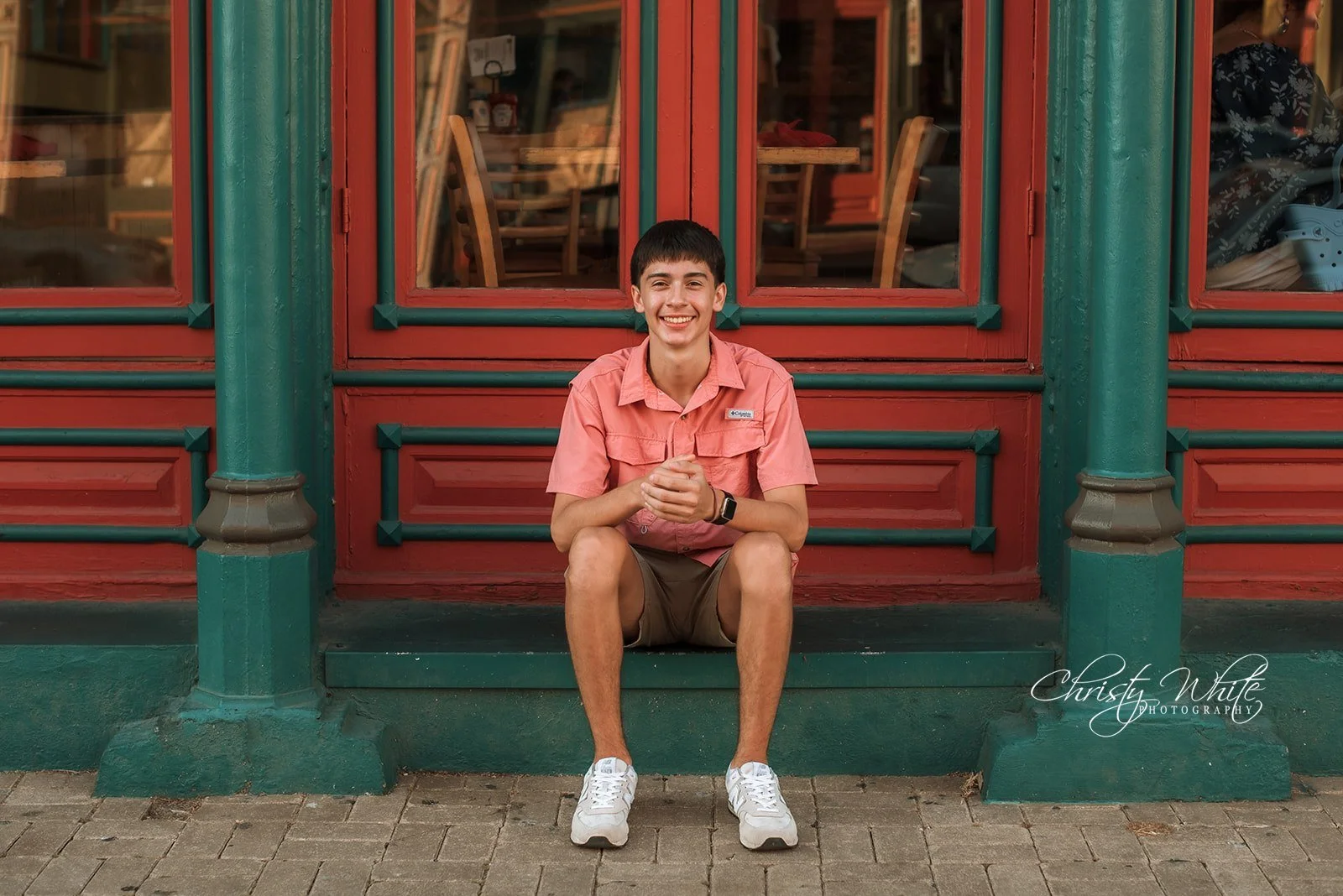 Class of 2027 senior portrait with the colorful architecture of the historic Galveston Strand