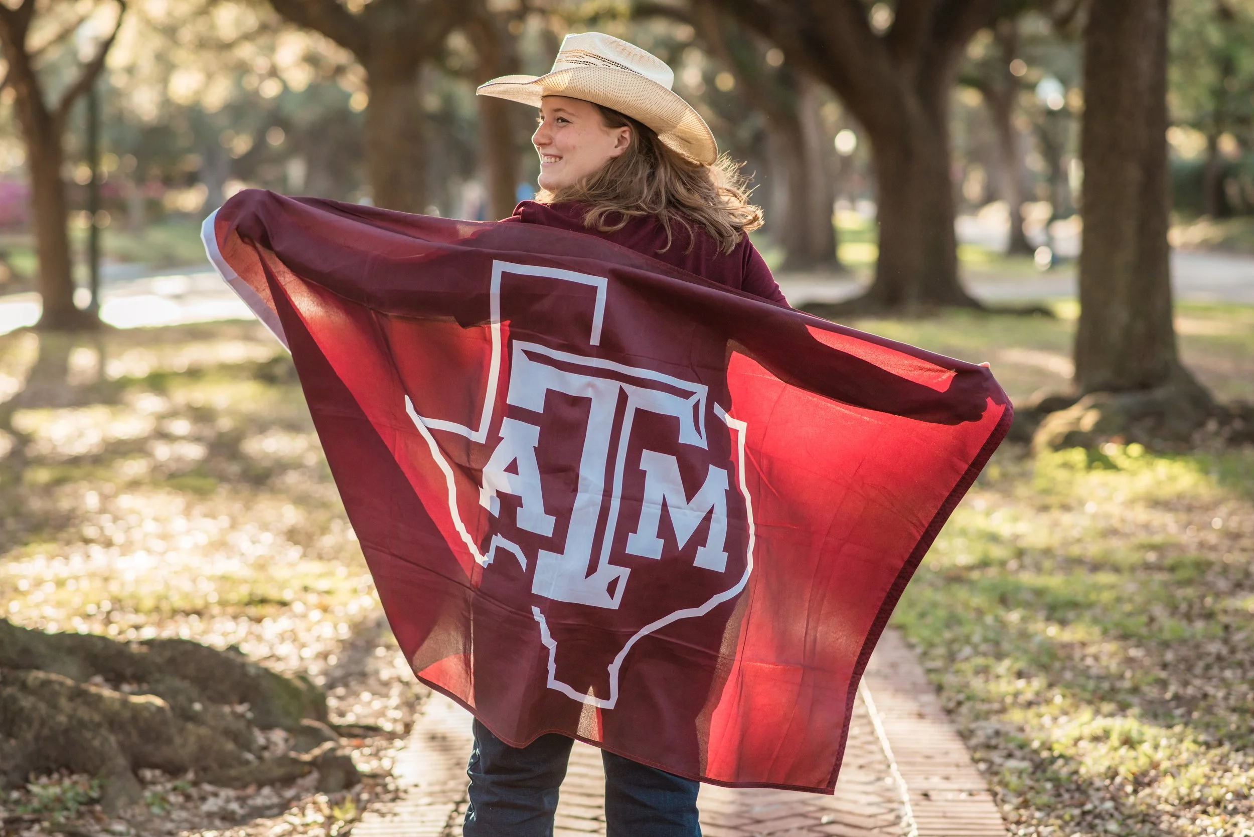 A high school senior showing off their college flag