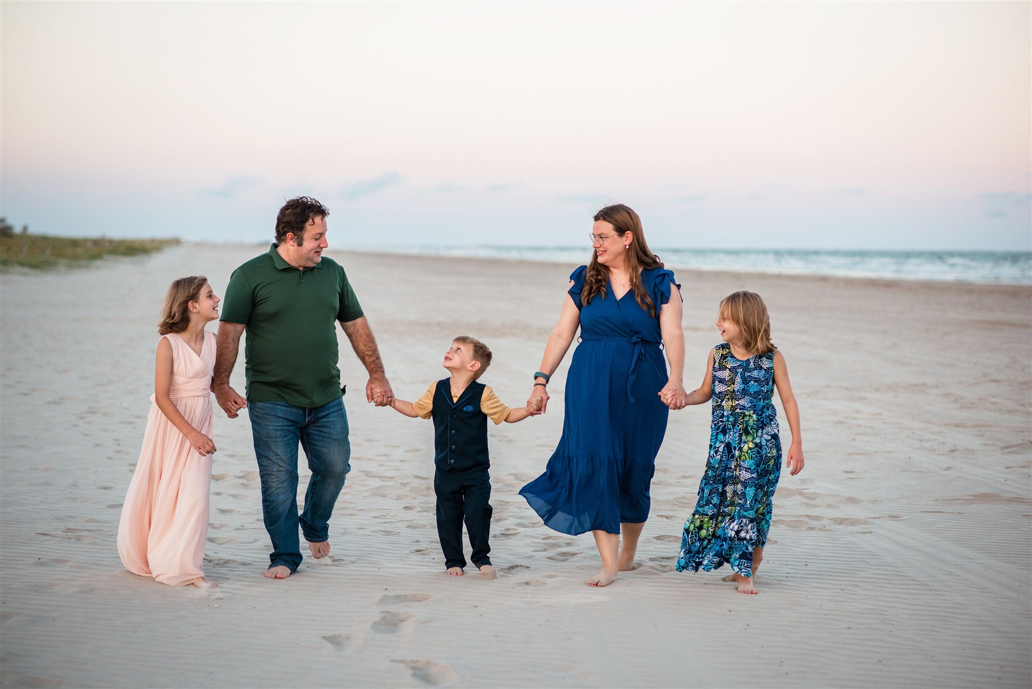 Family walking together during relaxed natural outdoor family photography session in Galveston Texas