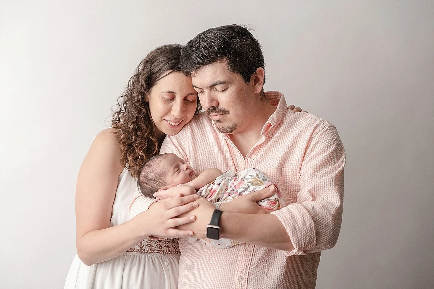 parents gently holding newborn baby during relaxed natural newborn photography session in Alvin Texas