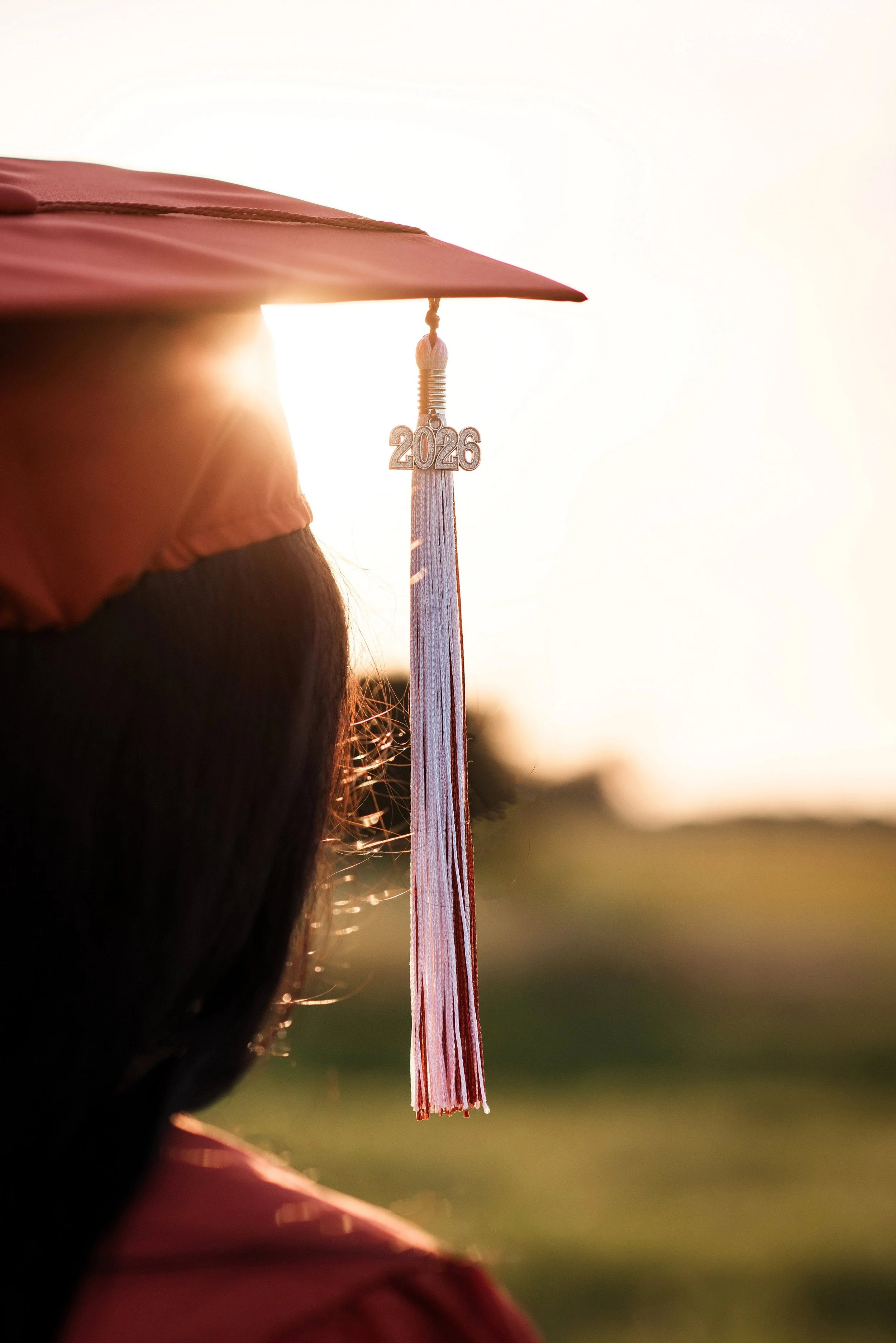 Golden hour graduation portrait featuring a Class of 2027 senior cap during a rustic Texas senior session