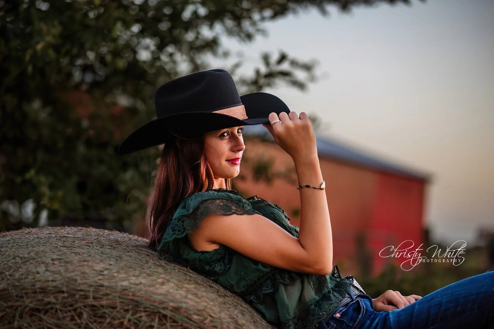 Angleton High School senior posing with hay bales during her country senior session