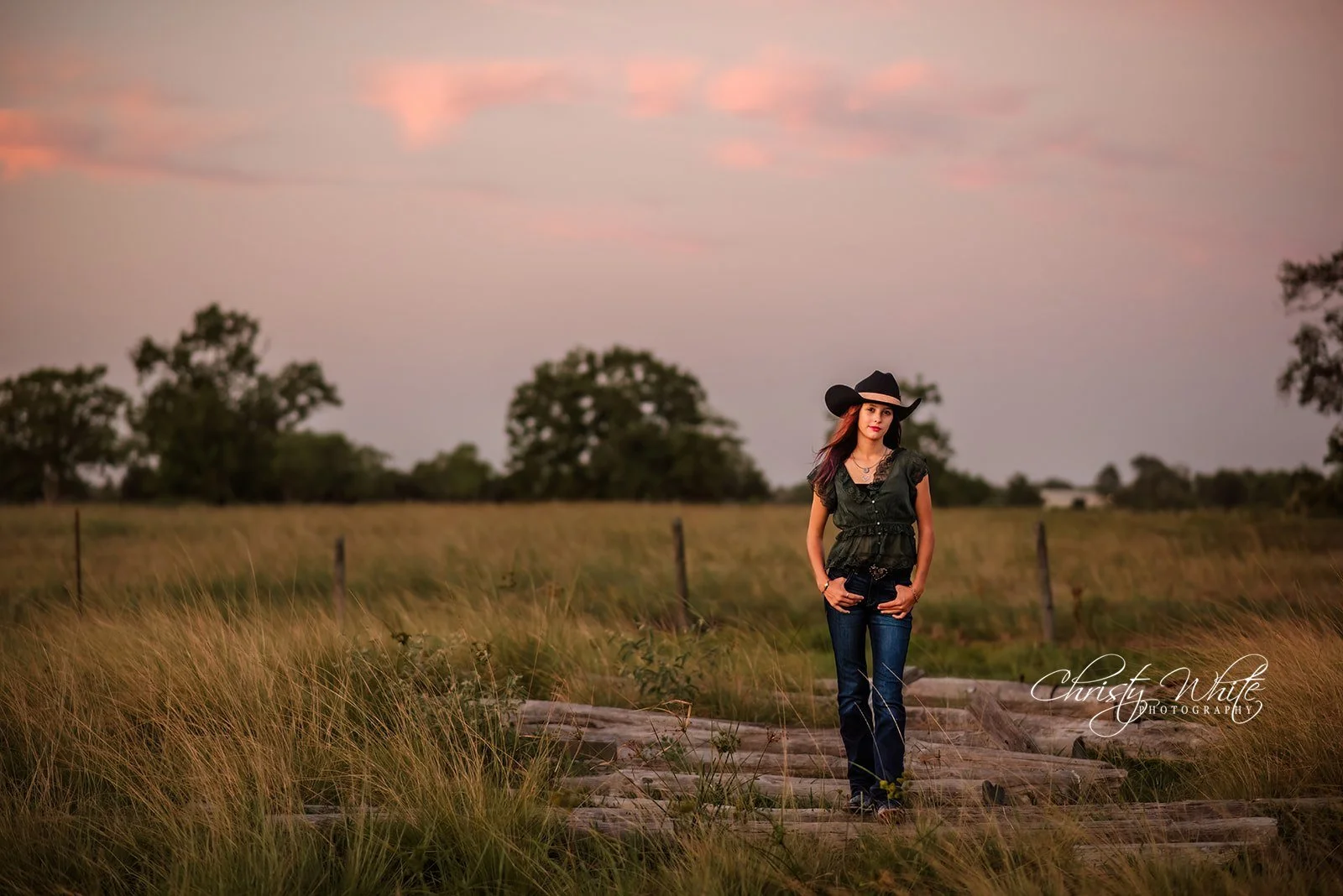 Outdoor portrait of an Angleton High School senior surrounded by a rustic Texas setting