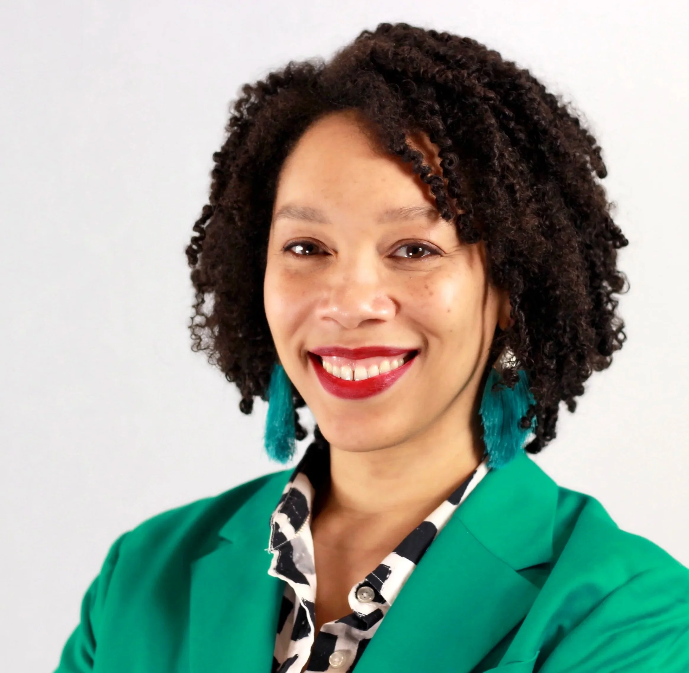 Portrait of strategist Lorrie Guess smiling in a green blazer.