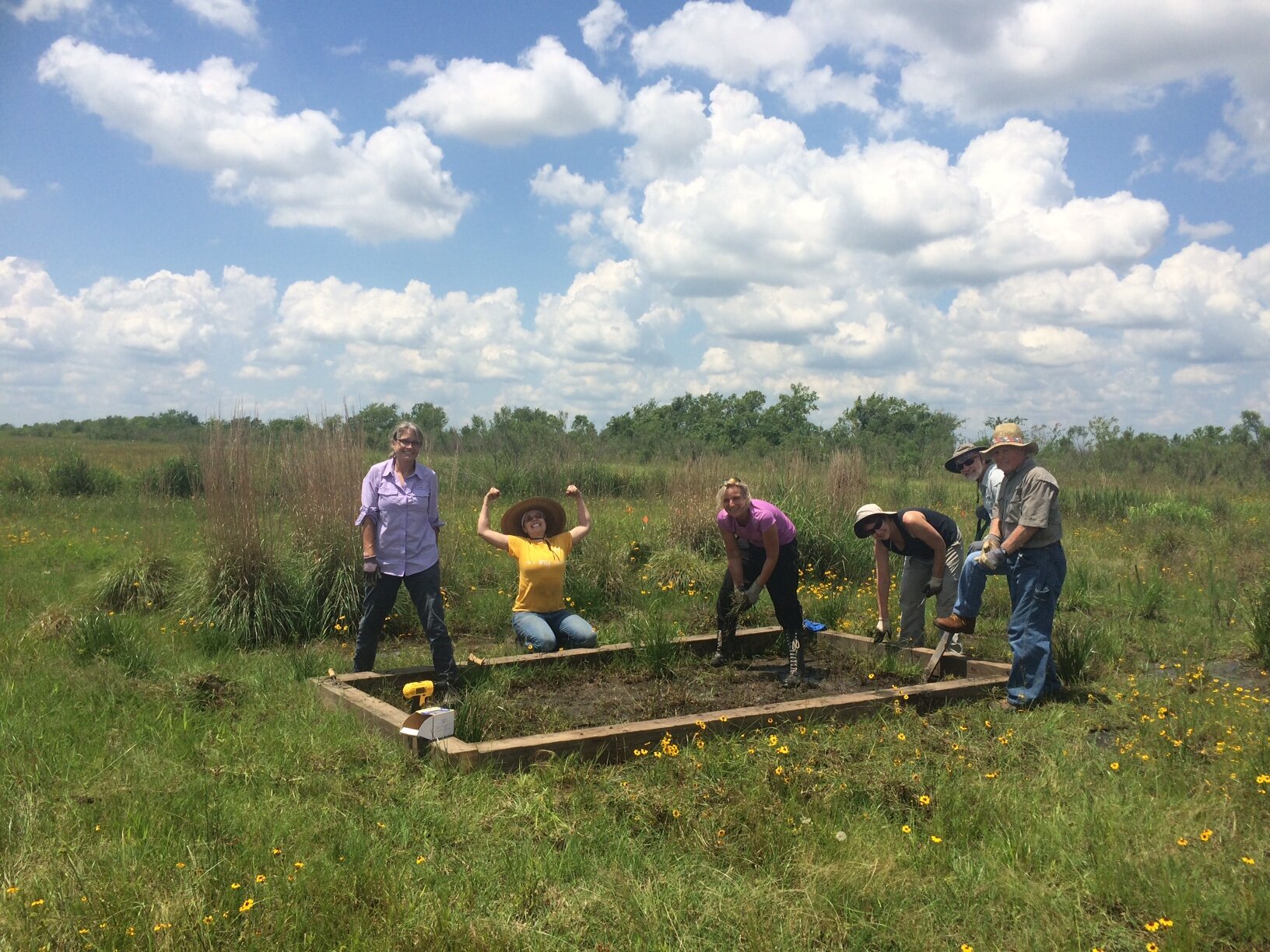 Group of people building a garden bed in the prairie.