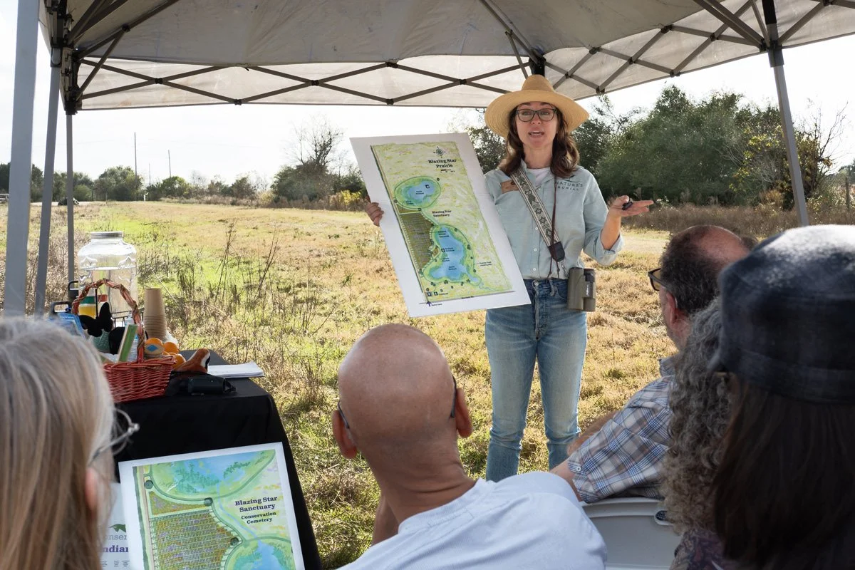 Woman holding a poster speaking to a group.