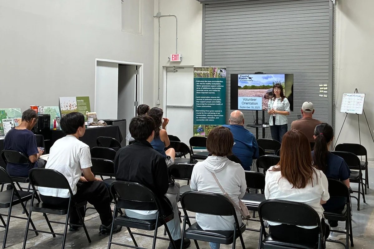 Woman holding a poster speaking to a group.