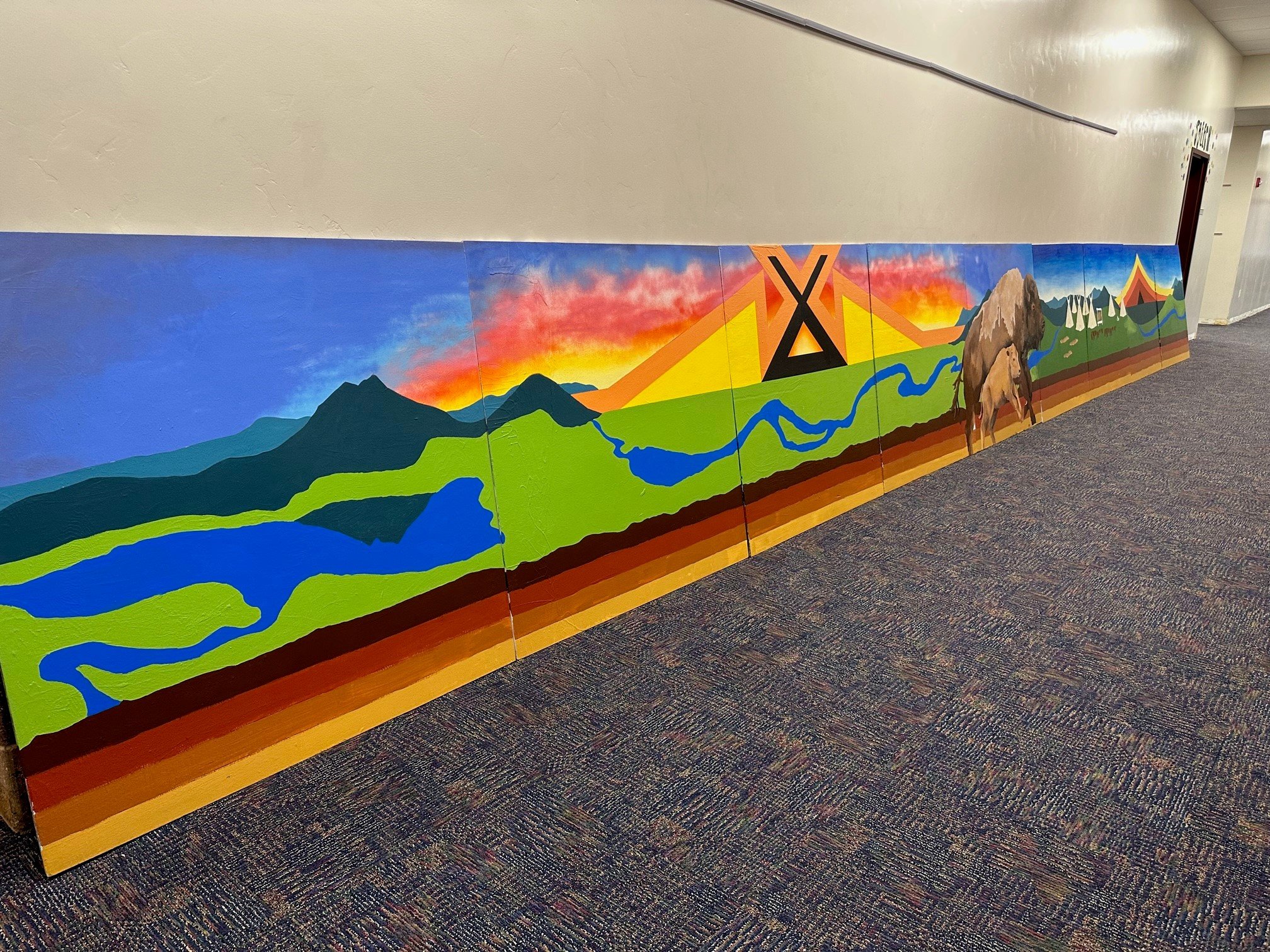  The first panel of the mural depicts the first Arapaho hill of life, birth/childhood, which is associated with the color yellow and the direction of east. (Photo Colleen Friday) 