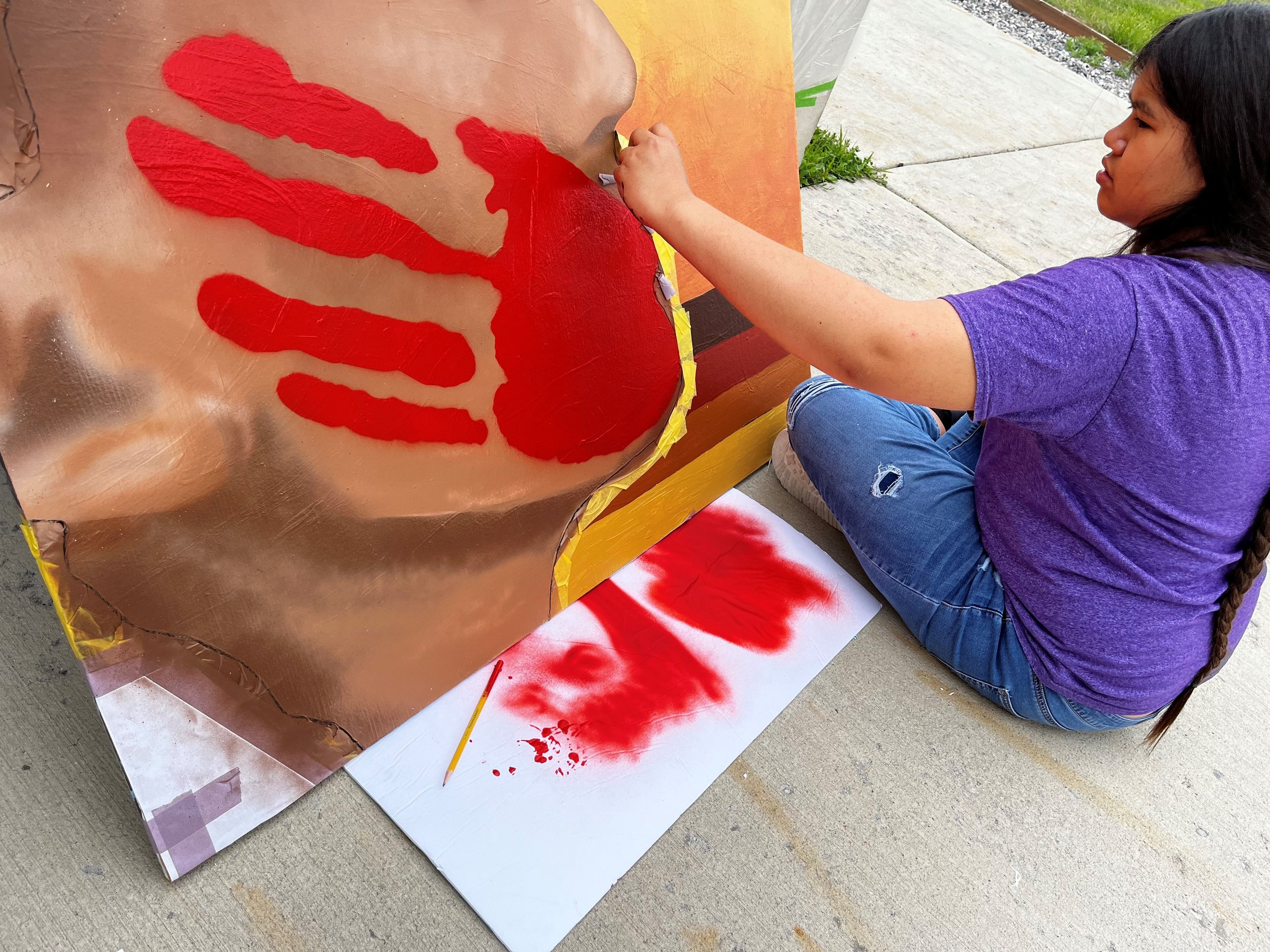  A student paints the in-progress mural. (Photo Adrienne Vetter) 