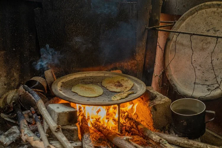 Tortillas on a plate cooking over Herminia's open fire pit