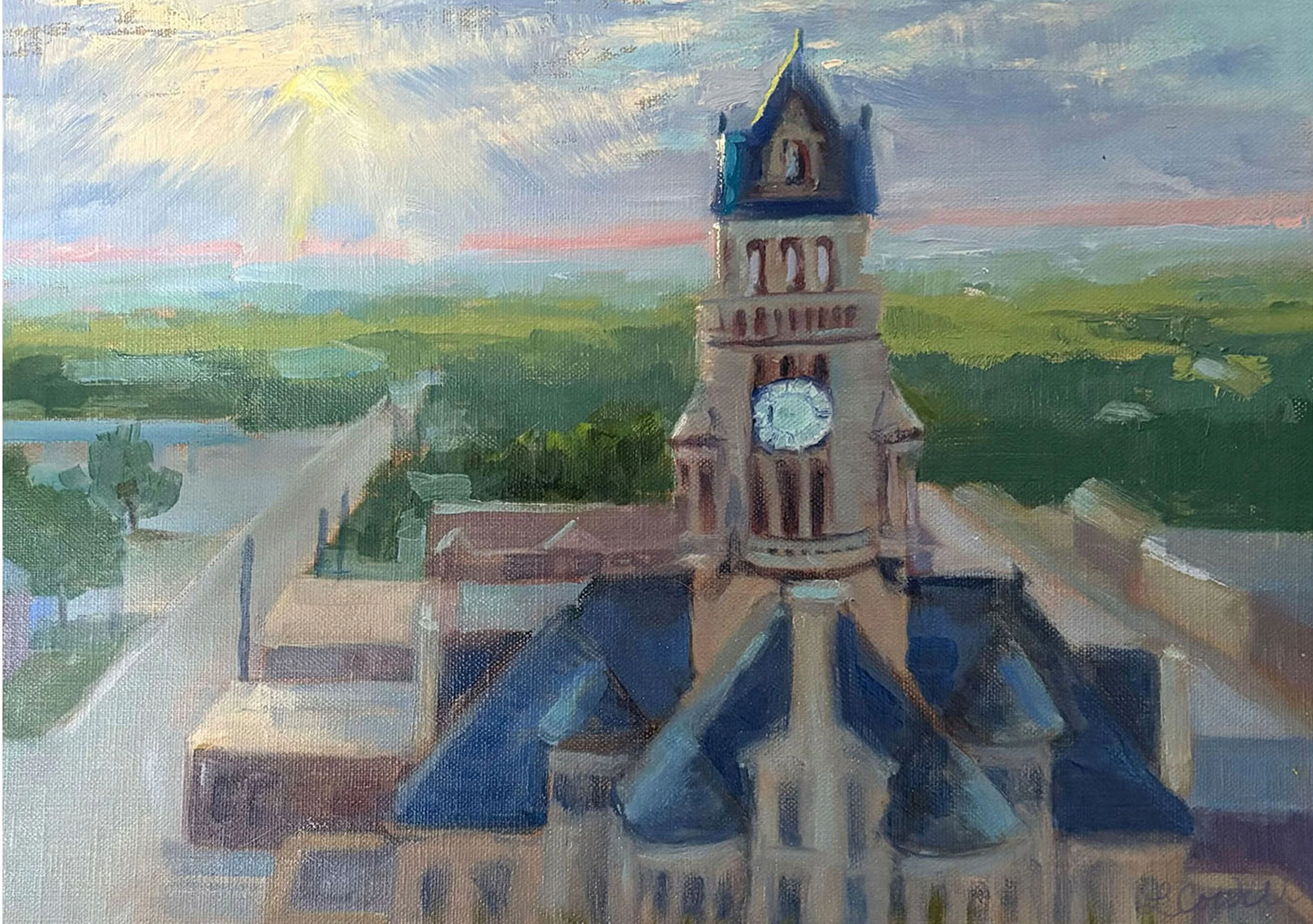 A modern impressionist oil painting in Local Heritage Collection of our renovated Courthouse with a blue roof and beige brickwork, viewed from above with town and sky showing a setting sun and some clouds in the background, available as prints.