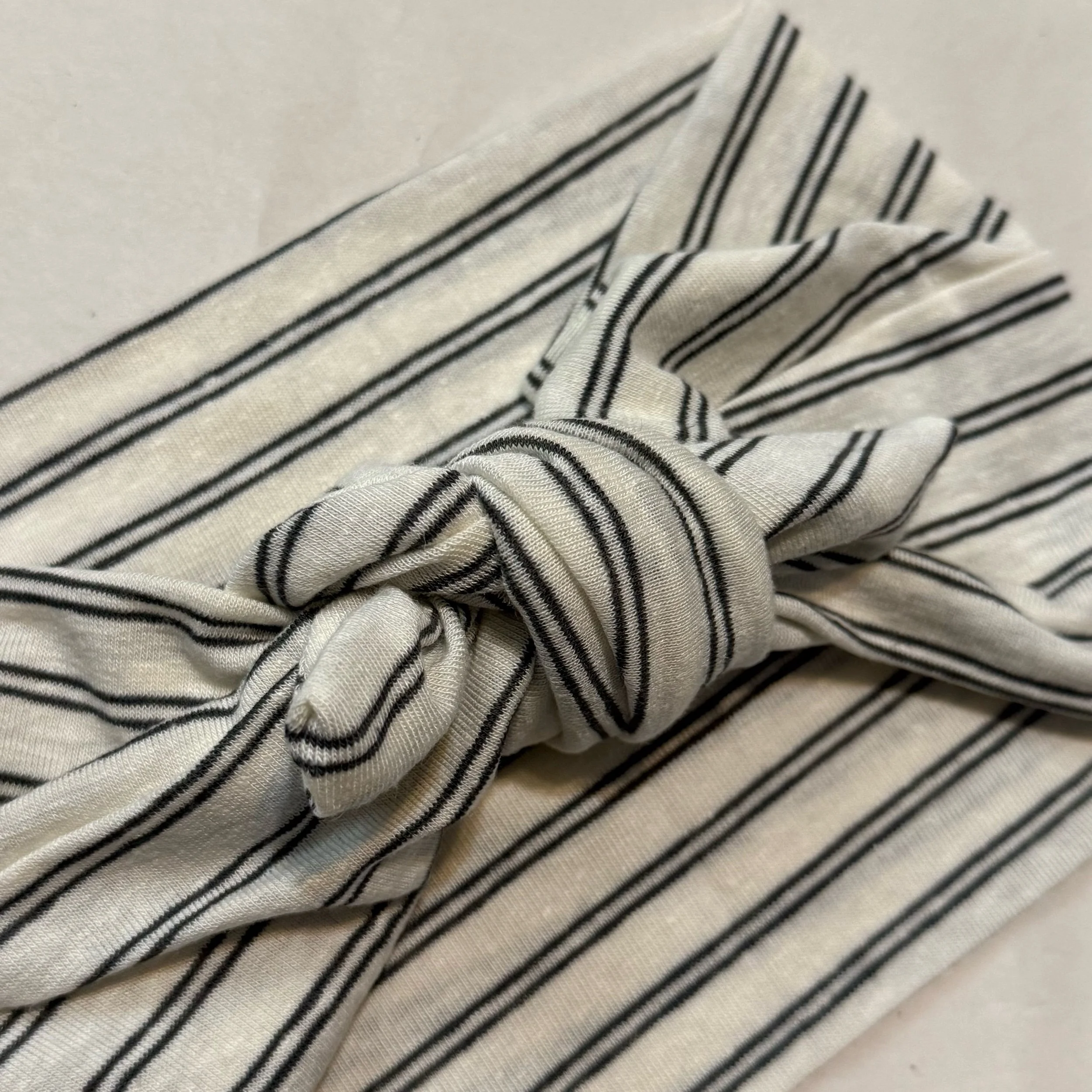 A black and white striped knit headband tide in a square knot