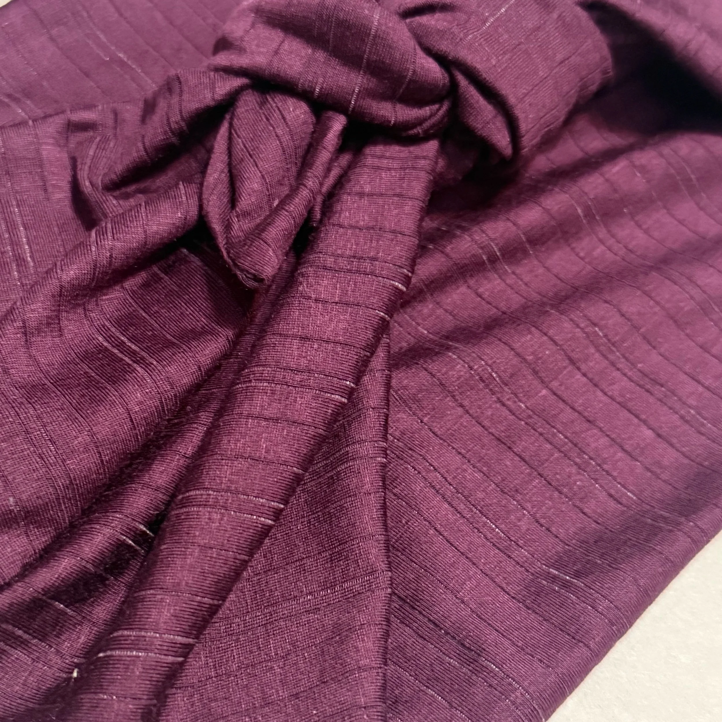 A plum purple with plum purple striped headband tide in a square knot