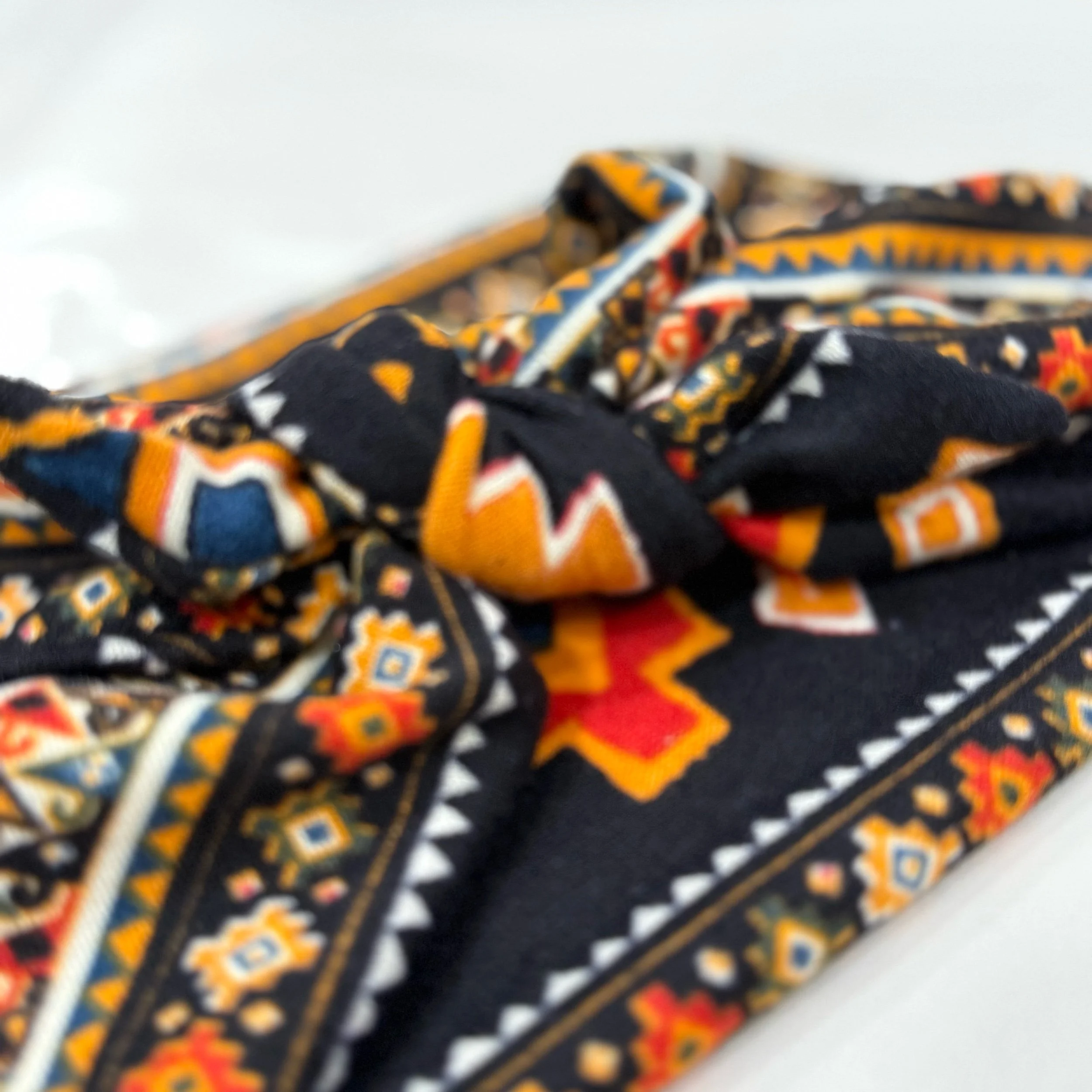 Adjustable southwest knitted fabric headband with colorful printed design, handmade by Seams by Sarah