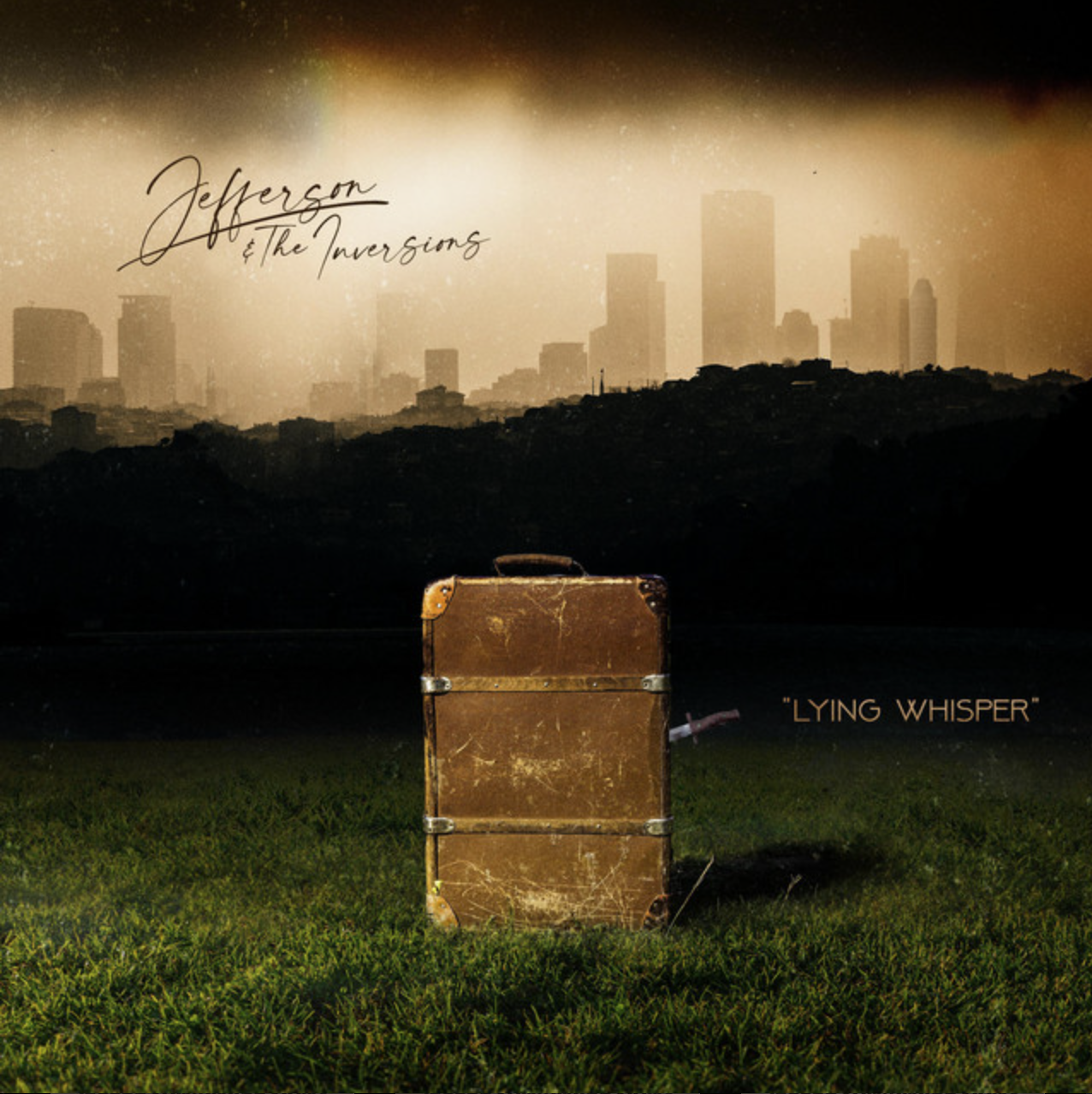 A vintage suitcase on green grass with a city skyline in the background under a sepia-colored sky. Text on the image reads "Jefferson & The Inversions" and "Lying Whisper."