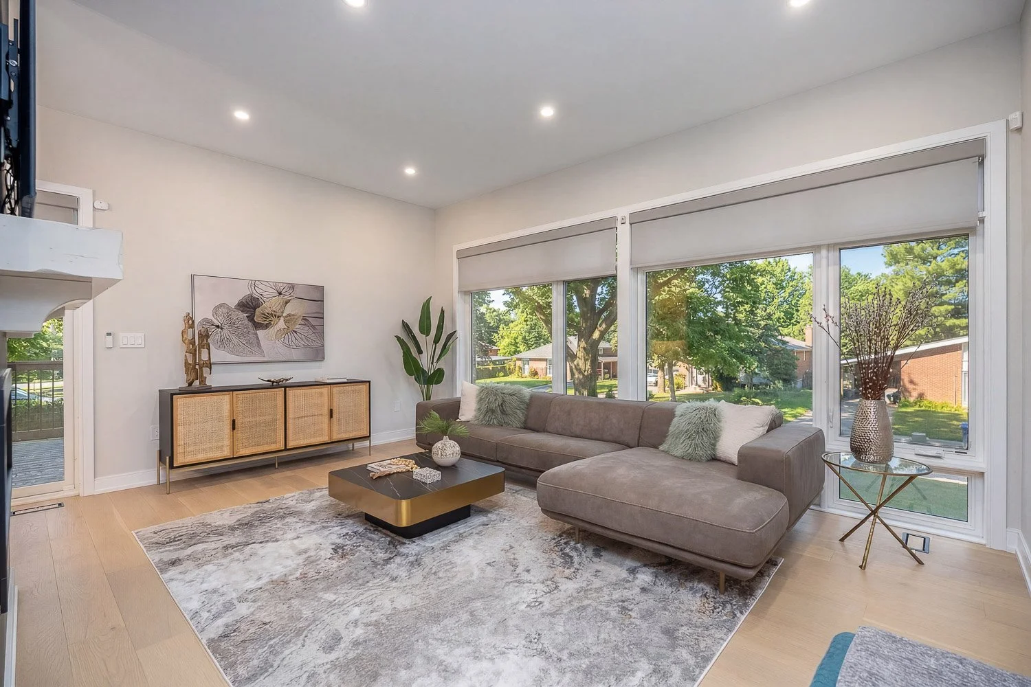 Contemporary family room featuring oversized picture windows, elegant staging, and a bright, welcoming atmosphere that highlights spacious everyday living