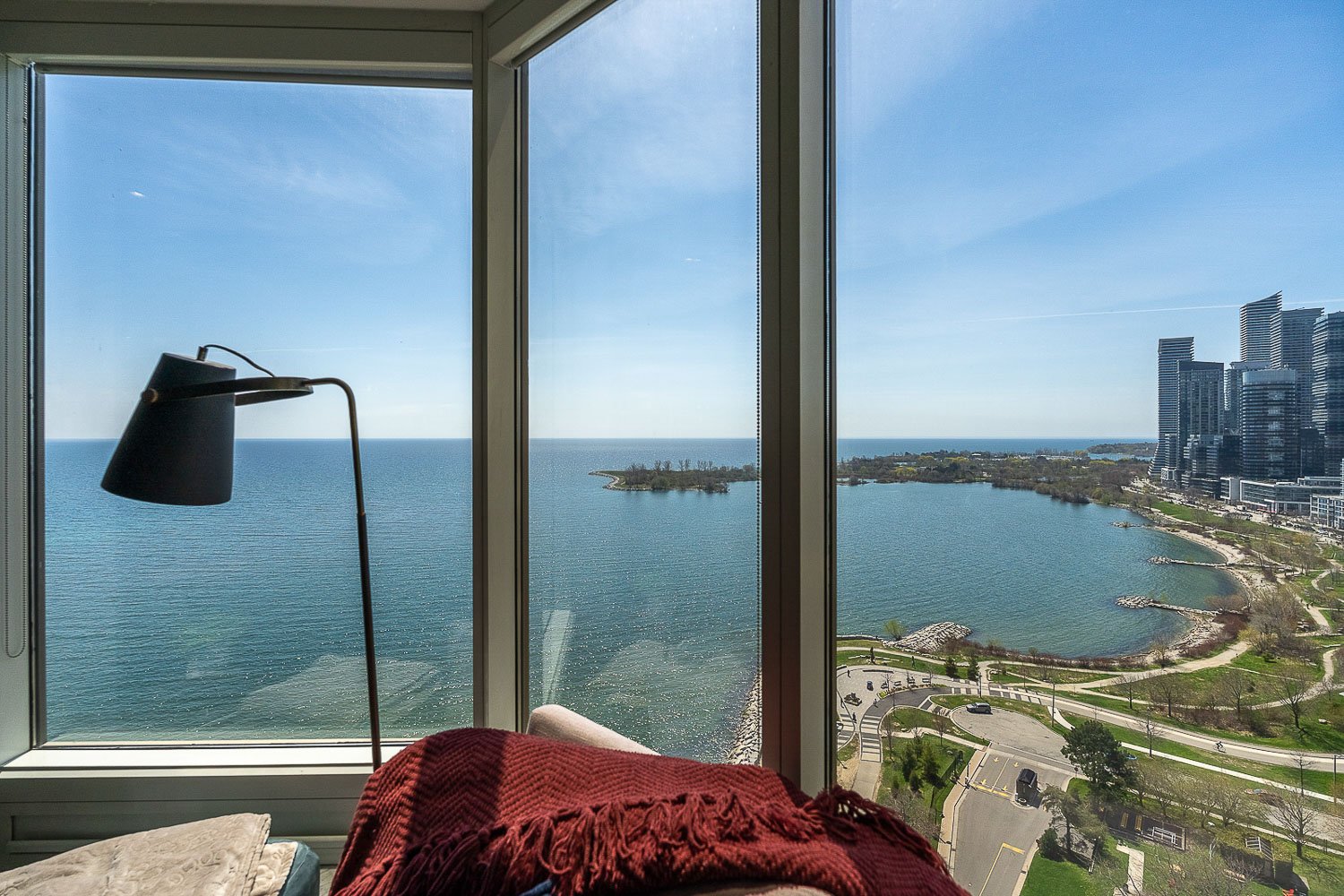 Floor-to-ceiling condo windows showcasing breathtaking Lake Ontario waterfront and Toronto skyline views