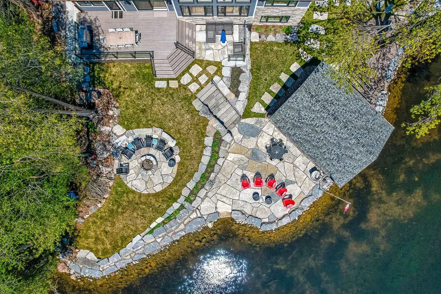 Top-down aerial view of luxury waterfront backyard and fire pit