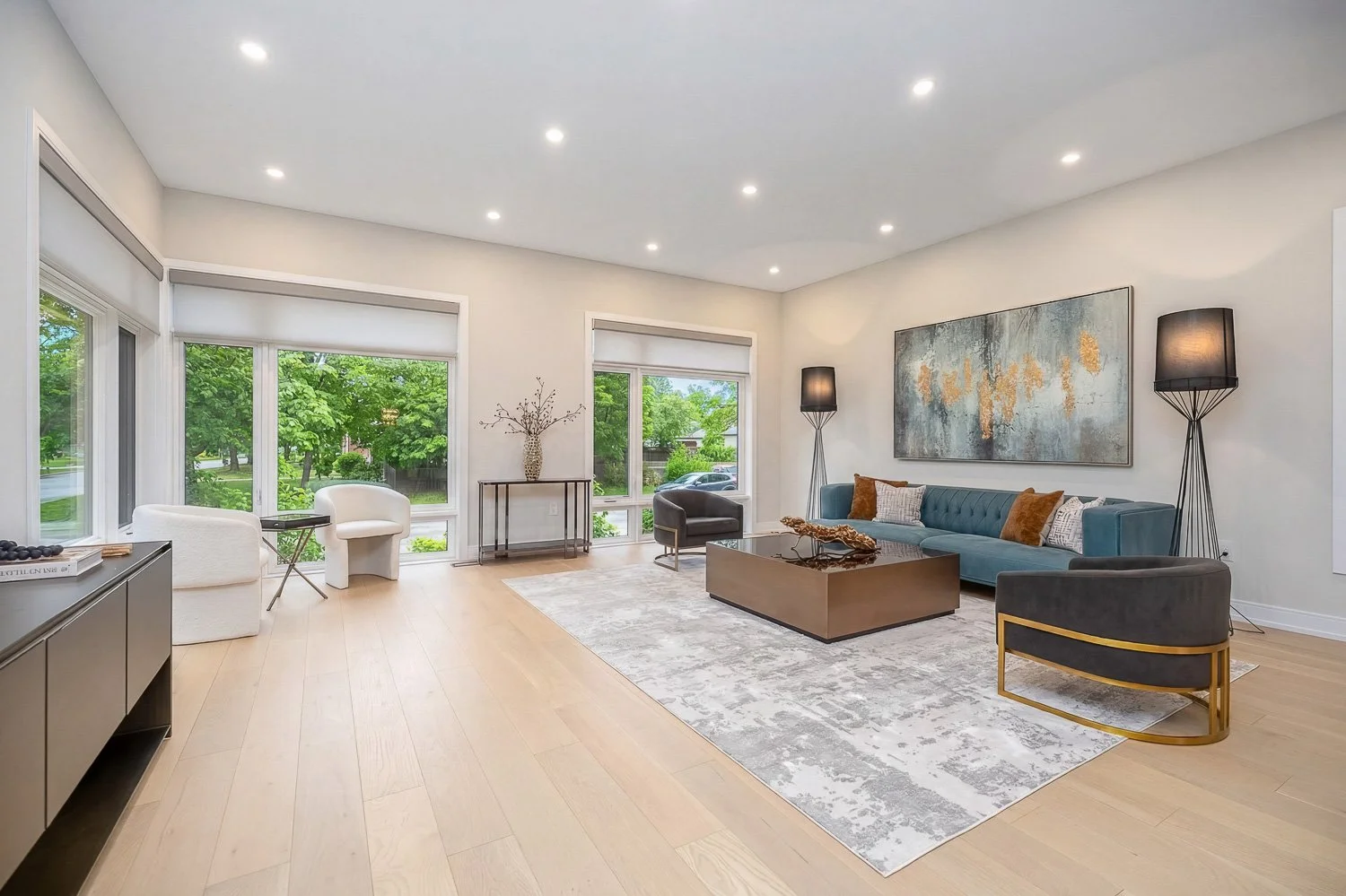 Sophisticated sitting area with expansive windows, refined contemporary décor, and abundant daylight creating an inviting space for relaxing and entertaining