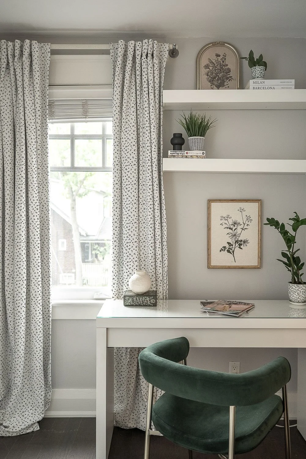 Home office nook with floating shelves, built-in desk, decorative styling and large window