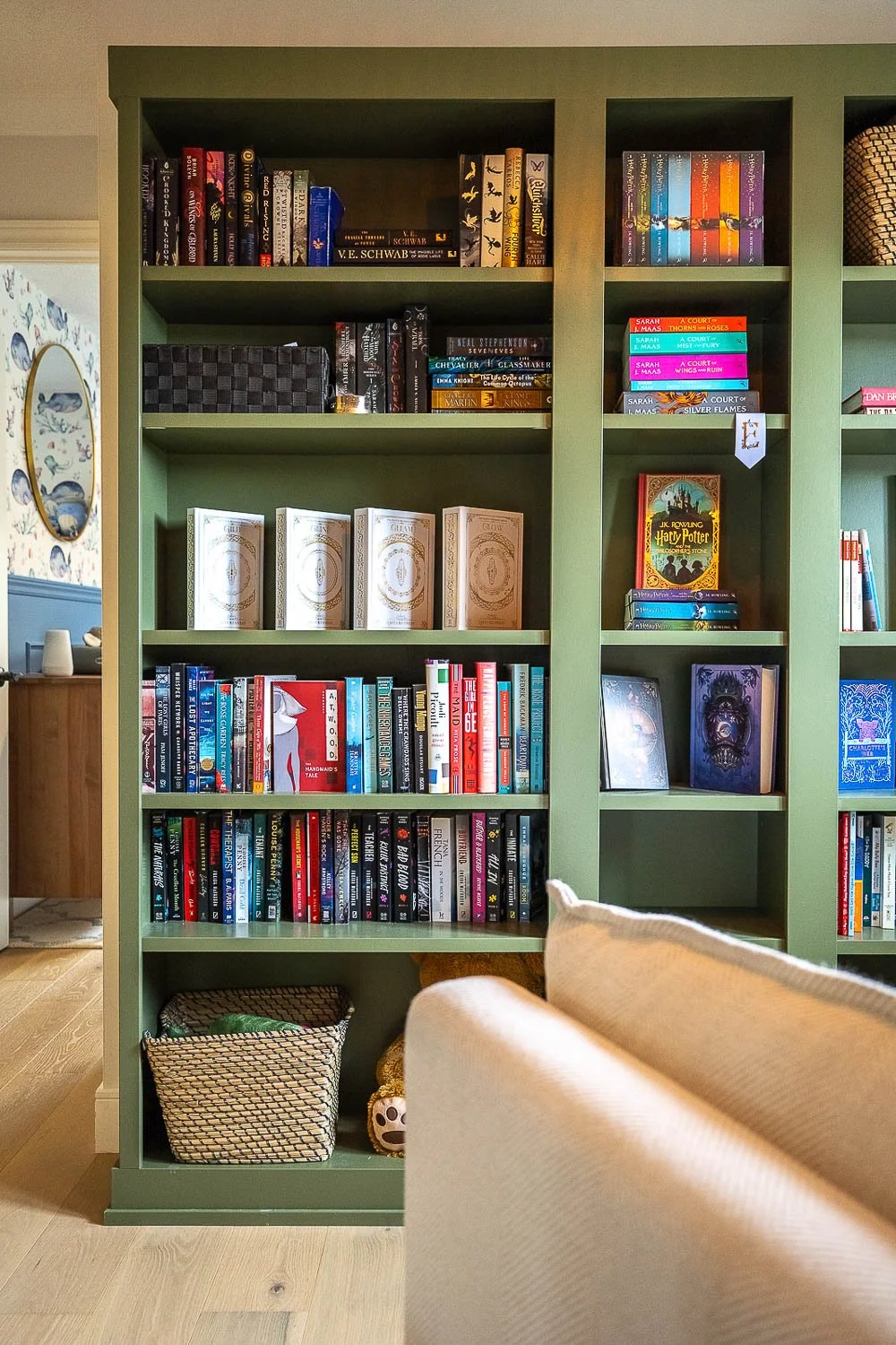 Built-in green bookshelf with custom cabinetry showcasing a curated home library
