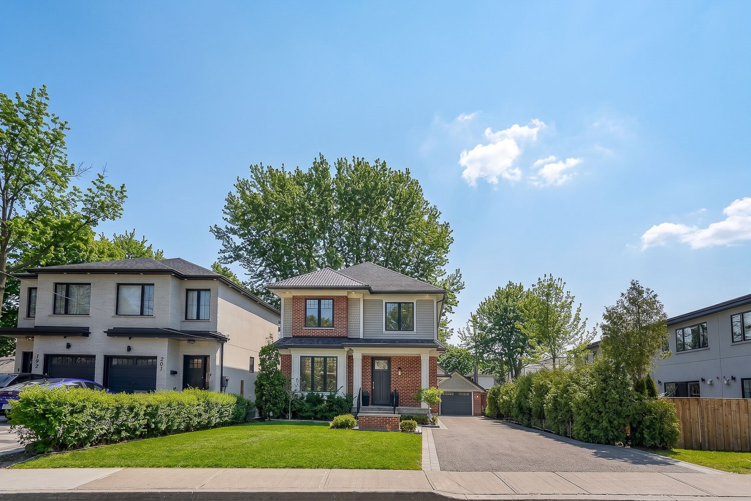 Modern detached home with landscaped front yard and long driveway