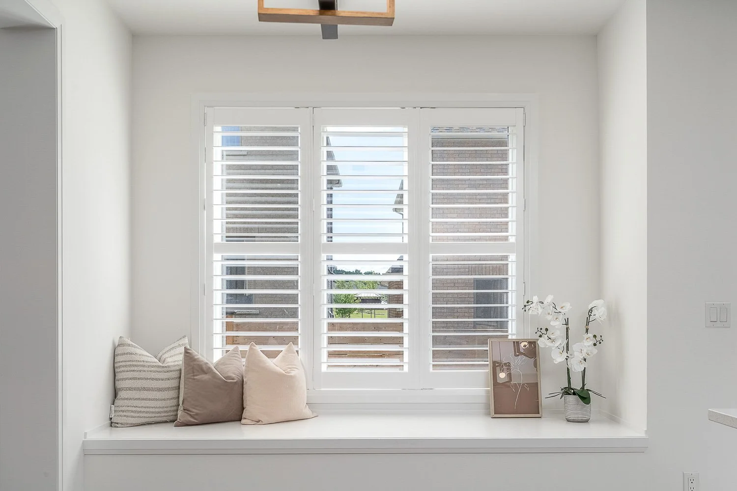 Bright window seat with plantation shutters, built-in bench and elegant modern décor