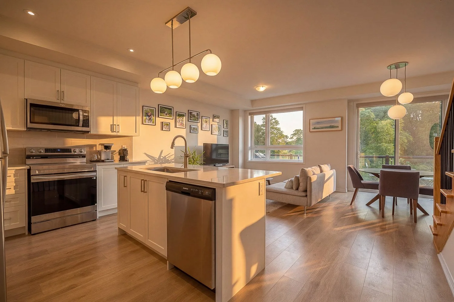 Open-concept kitchen and living room with quartz island, stainless steel appliances and balcony access
