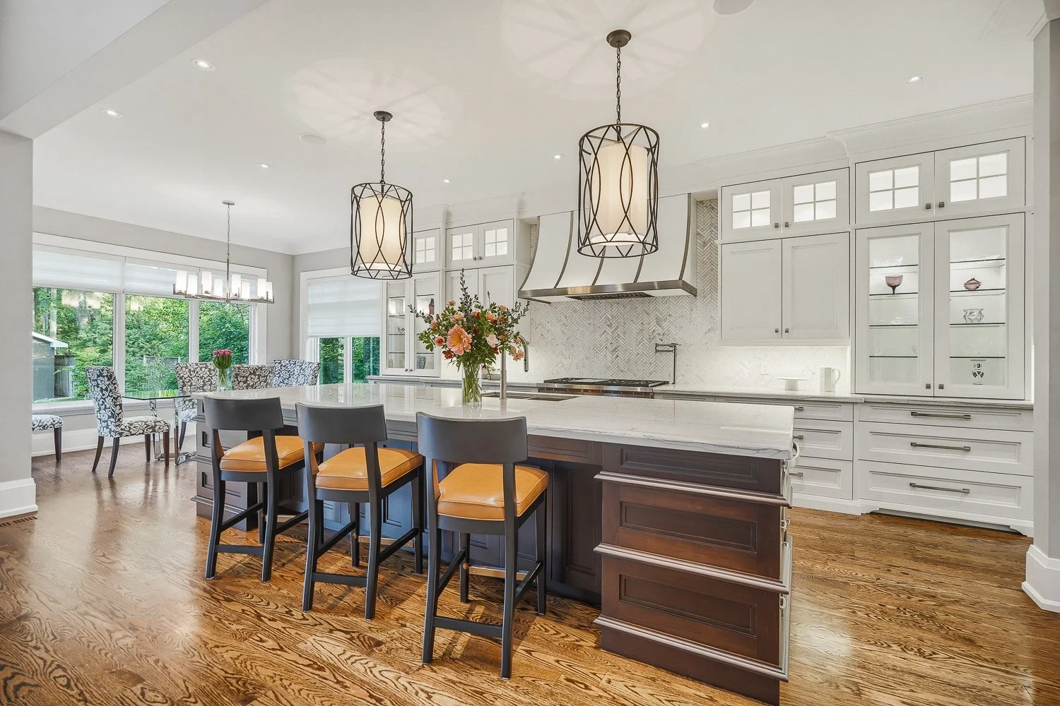 Upscale chef’s kitchen featuring custom cabinetry, a statement quartz island, premium appliances, and elegant lighting, seamlessly connected to the bright dining area for effortless entertaining