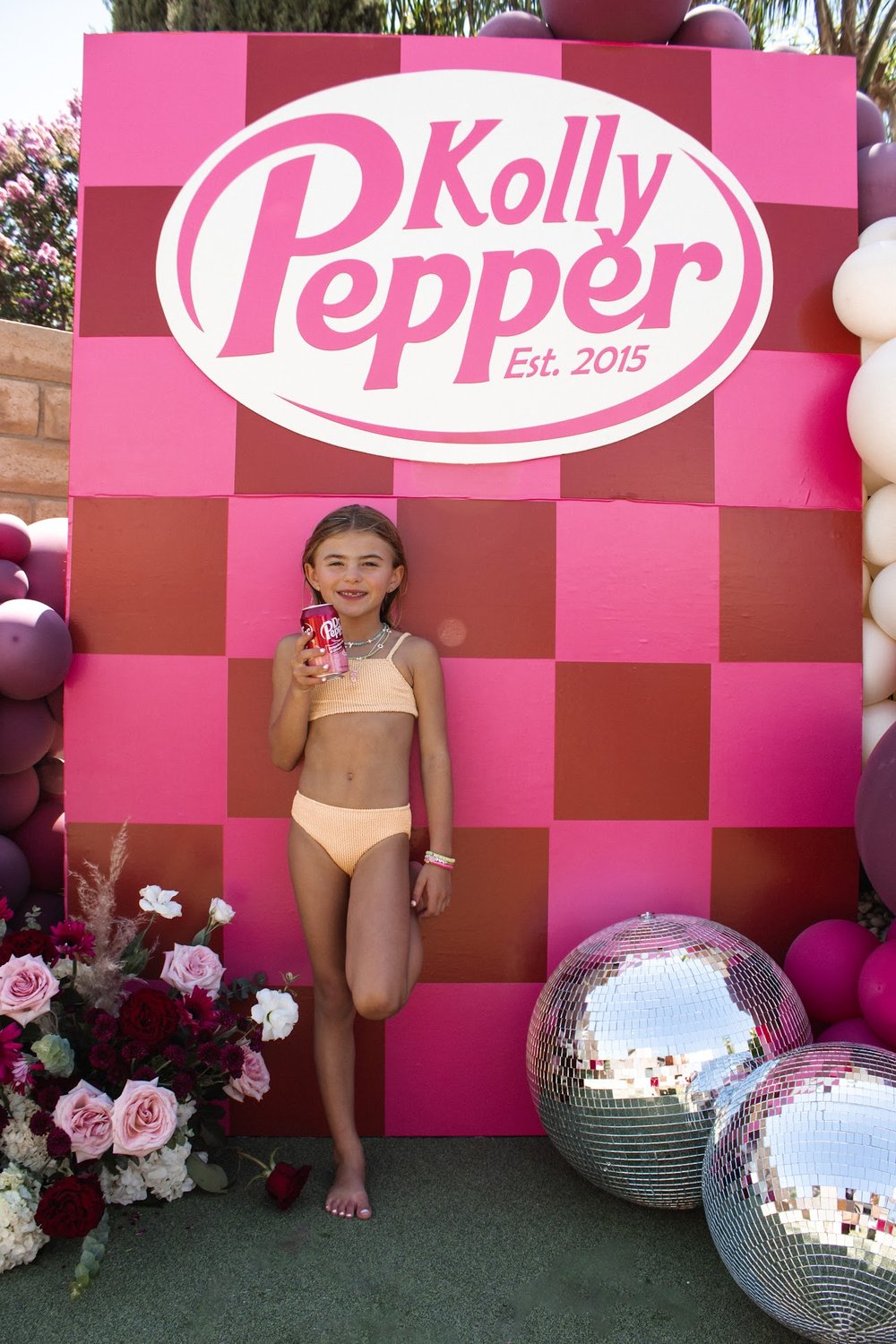 kid wearing a swimwear and holding a can of Kolly Pepper
