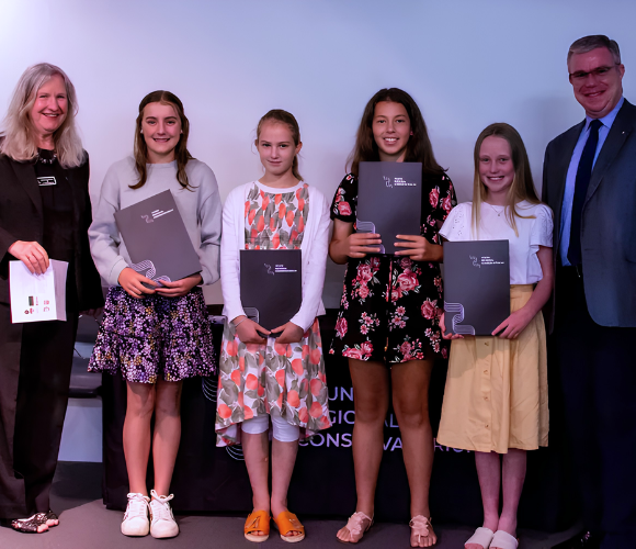scholarship awardees stand in line to accept their awards