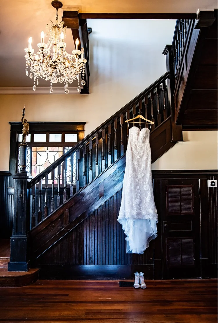 Wedding gown hanging by the historic staircase