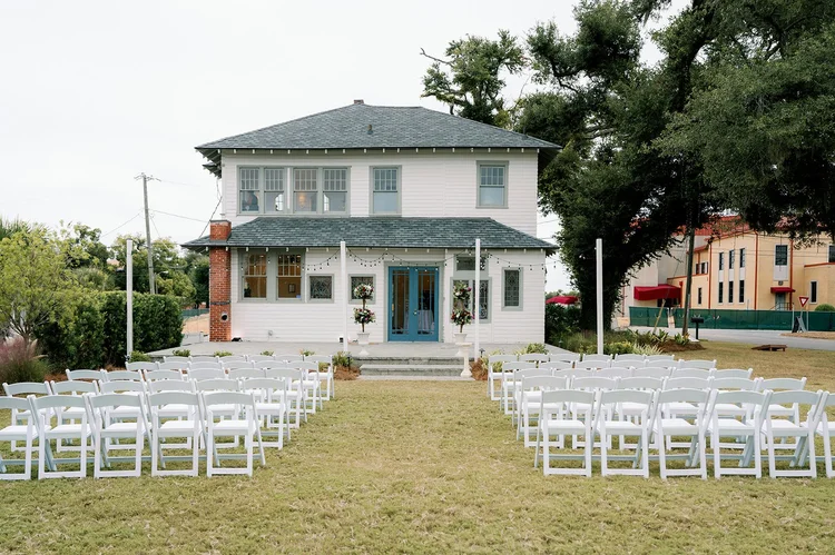 Ceremony chairs set on the lawn facing the house