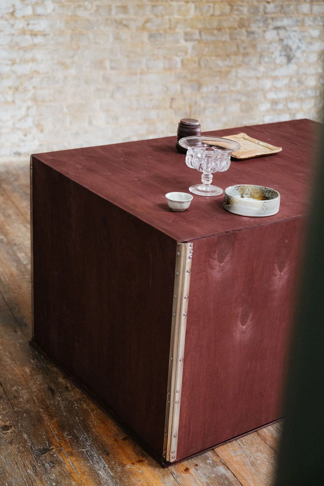 Decorative objects layered on a ruddy violet stained wooden crate