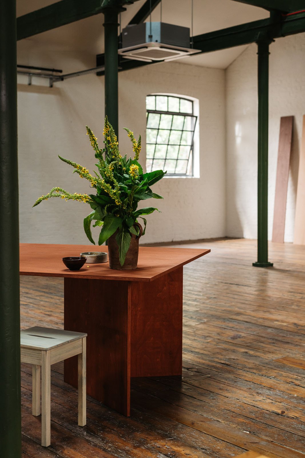 Wood table stained in a warm red coloured stained with wooden stool coloured with light blue stain.